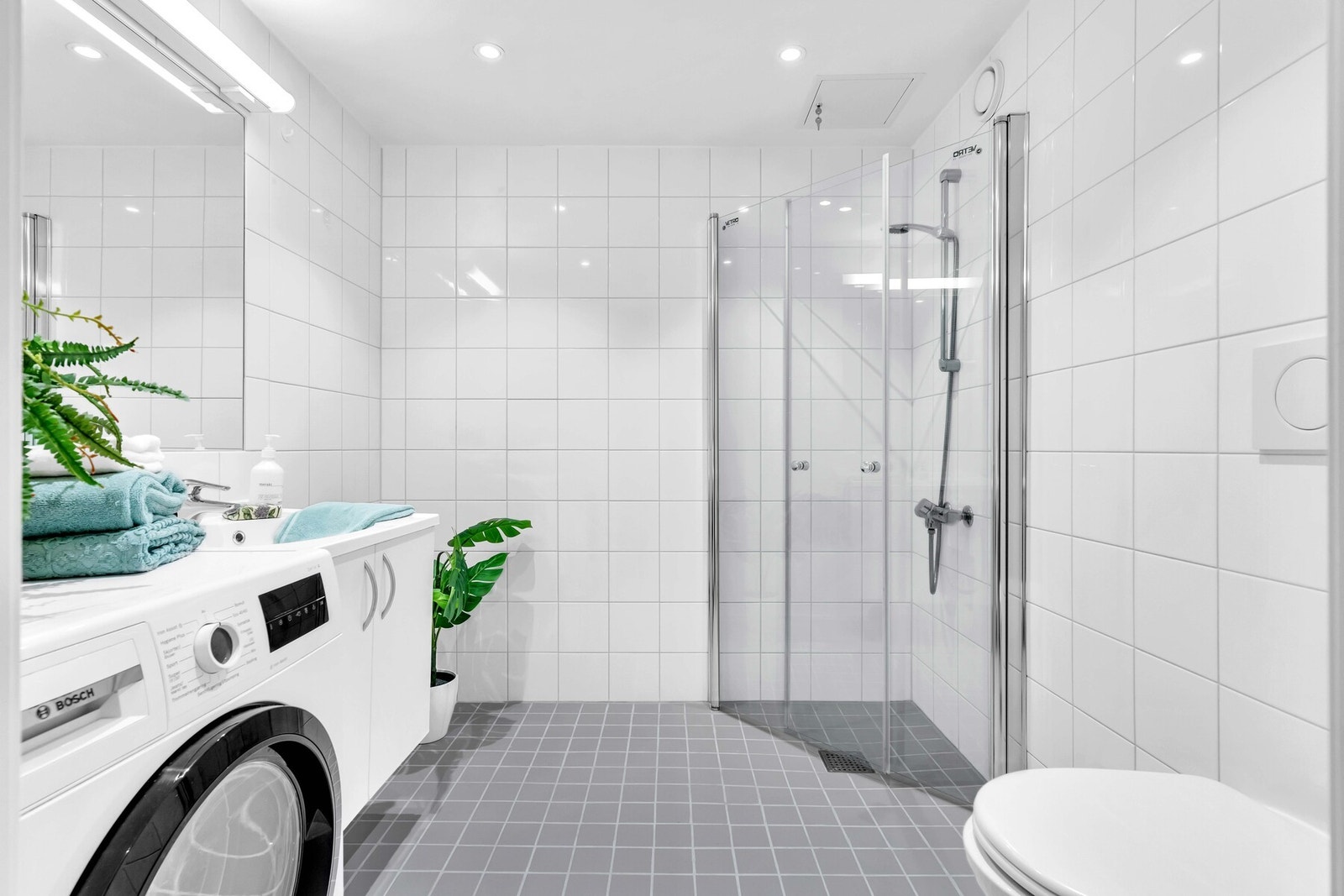 Helfliset bad med varmekabler og opplegg for vaskemaskin og tørketrommel. Nye LED-downlights i 2025. Galleribilde