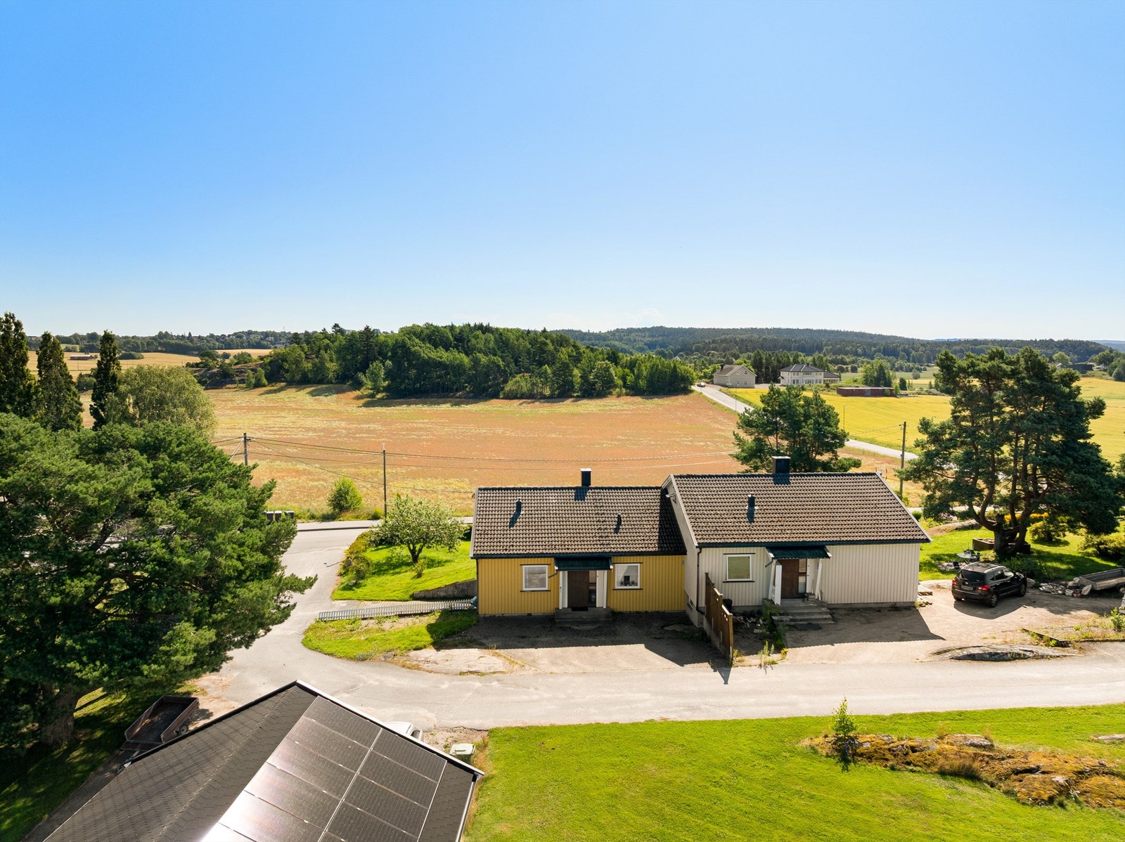 Boligen har biloppstillingsplass både ved inngangssiden og ved innkjøringen til garasjen på siden av bygget. Galleribilde