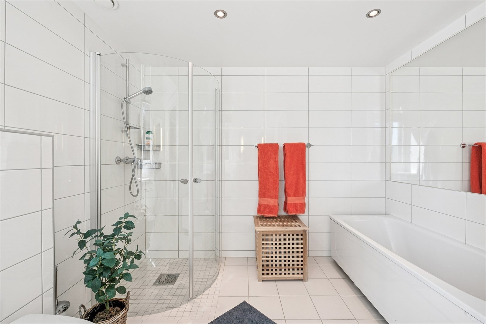 Det er et romslig bad, med dusjhjørne, badekar, vegghengt klosett og servant med underskap Galleribilde