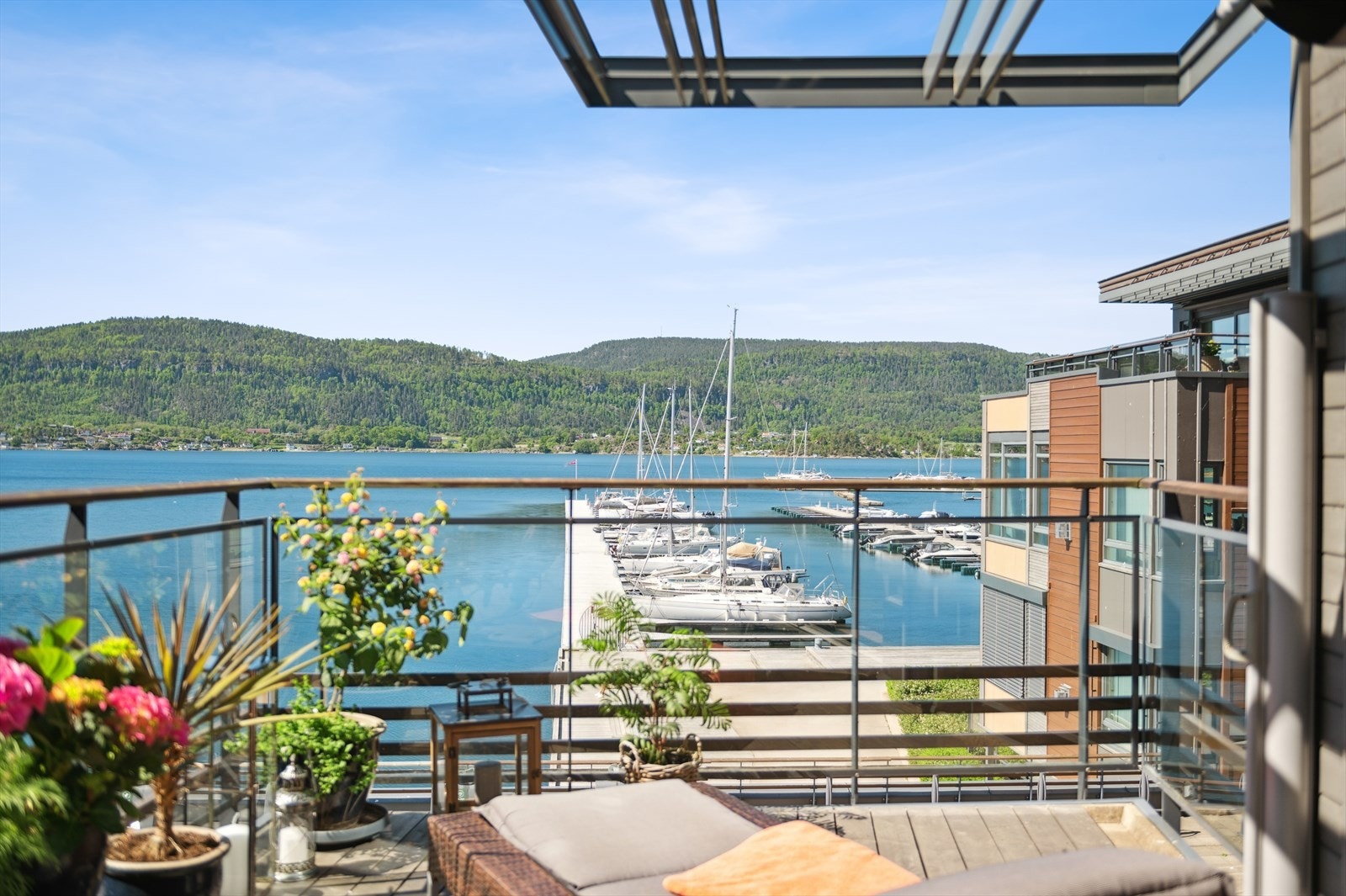 På balkongen kan du både nyte solen og den flotte utsikten mot sjø og båtliv Galleribilde