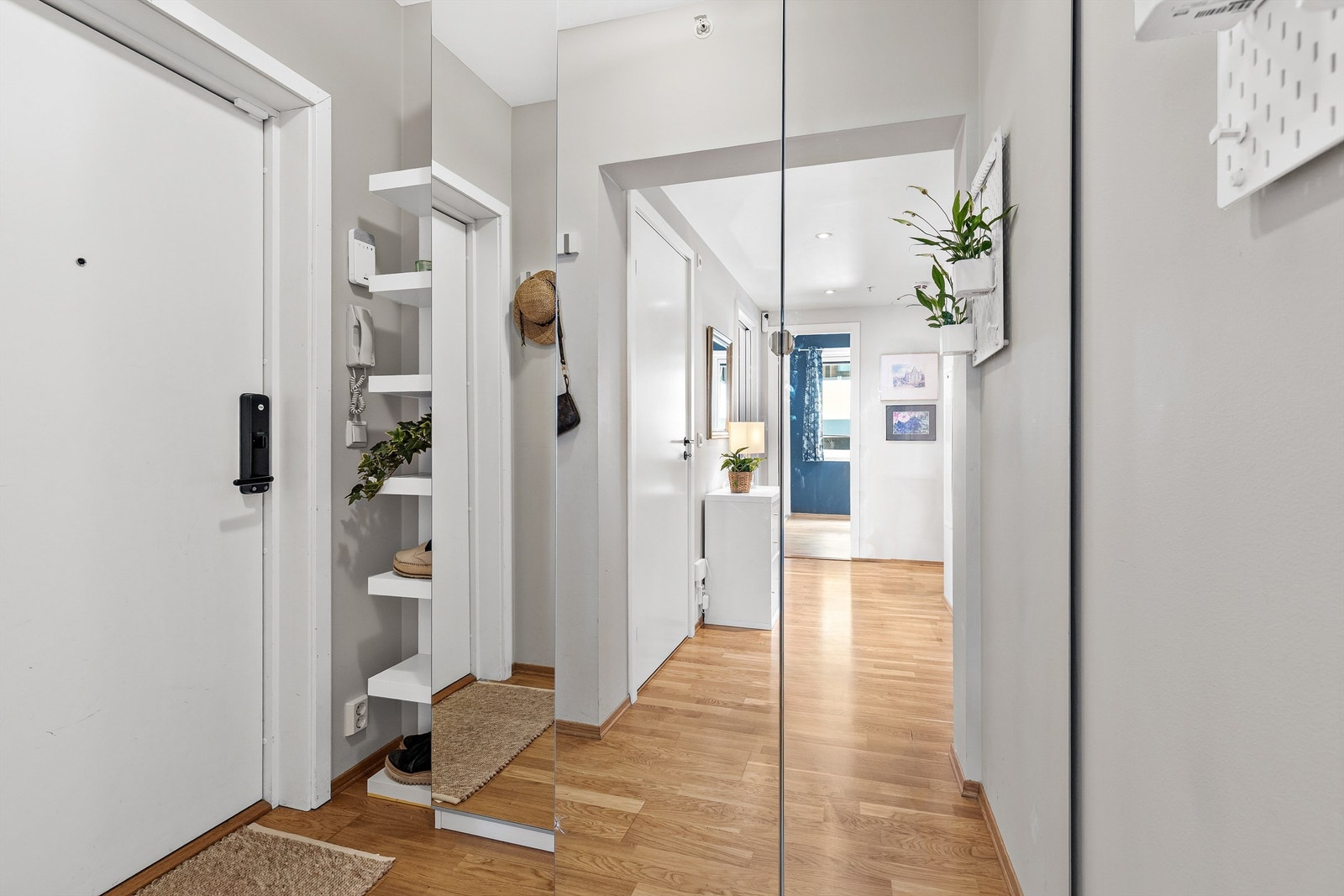 Velkommen inn! Entréen er lys og innbydende med plass til å henge fra seg yttertøy og sko. Her er det også adkomst til boligens innvendige bod for ytterligere oppbevaring av utstyr og sesongklær. Galleribilde