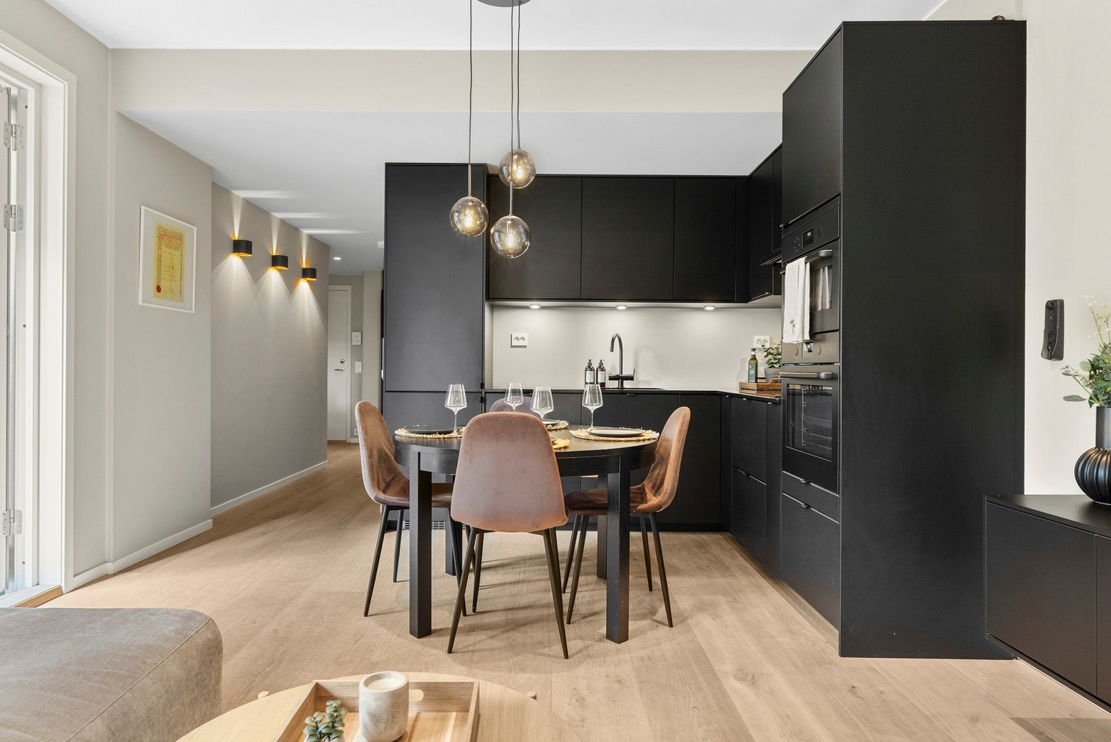 Moderne stilfult kjøkken med sorte fronter og integrerte hvitevarer. Galleribilde