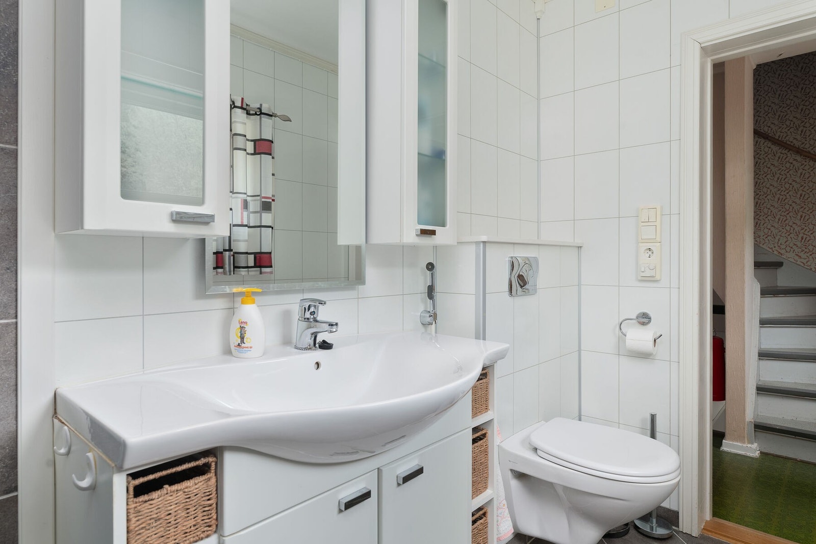 Badet har servant på innredning, over- og underskap, vegghengt toalett og dusjhjørne Galleribilde