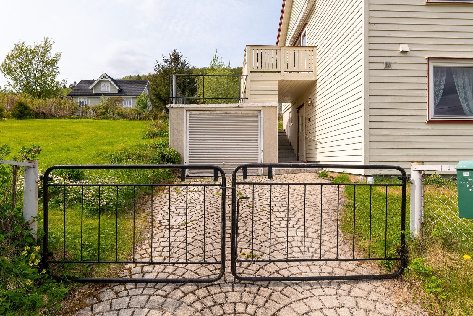 Opparbeidet tomt med plen, busker og trær, samt innkjørsel og gårdsplass med betong Galleribilde