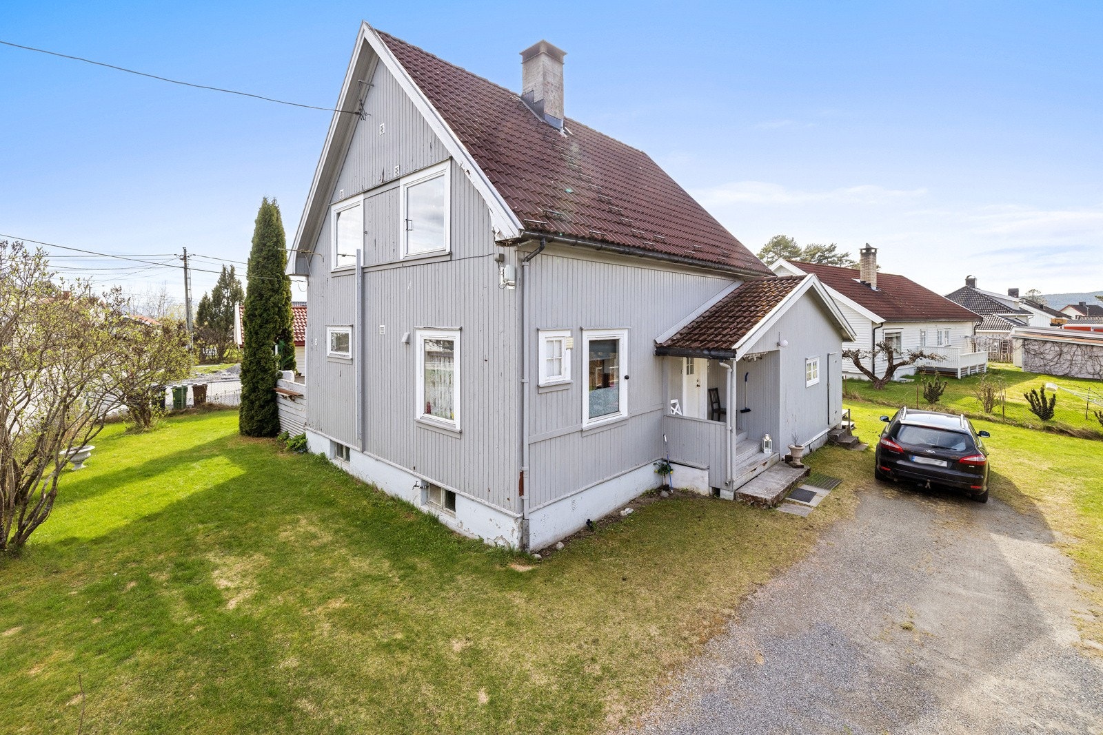 Solrik tomt og hyggelig hage med gressplen og prydbusker Galleribilde