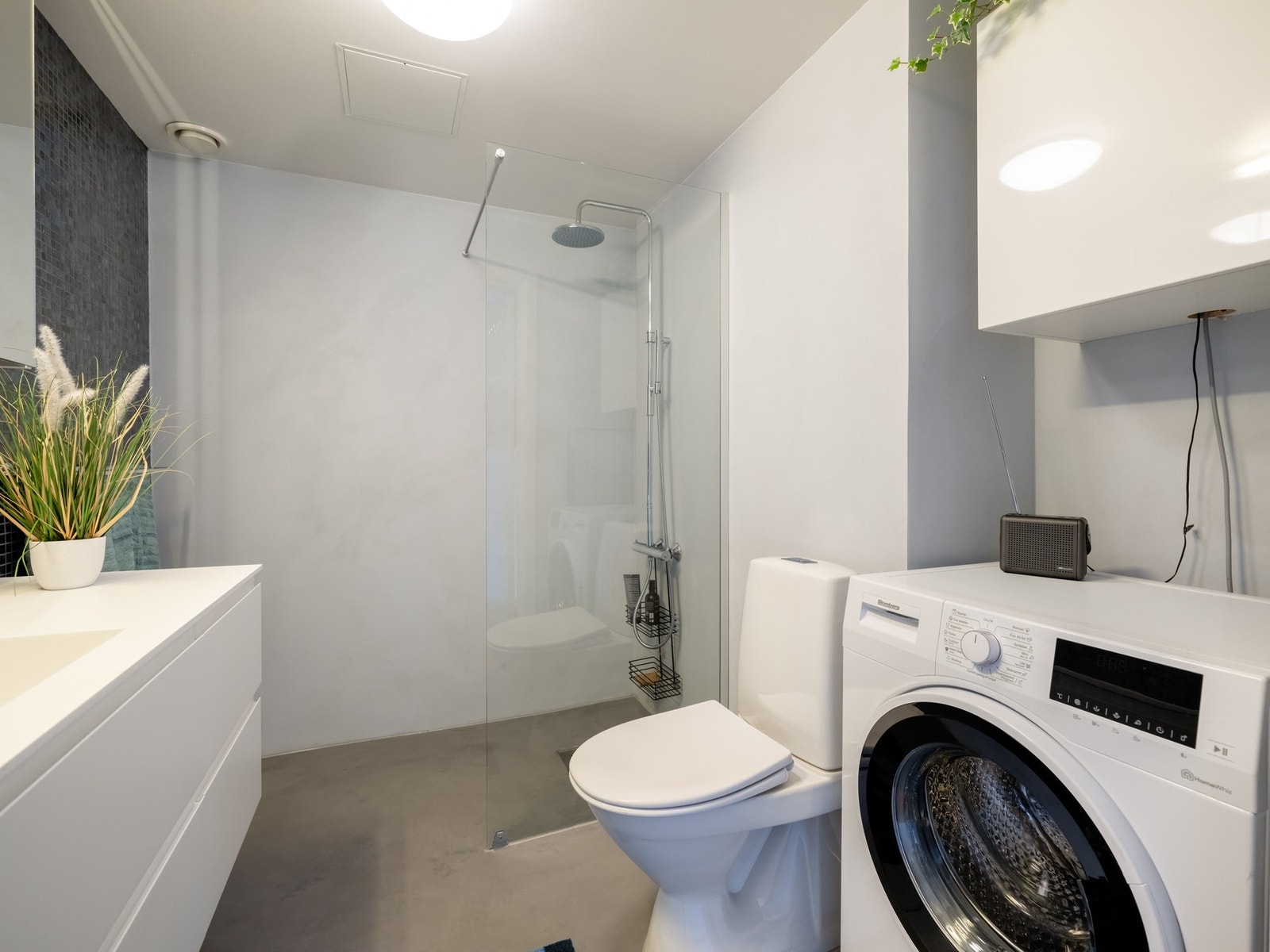 Videre er badet utstyrt med dusjvegger av glass og dusjgarnityr, samt toalett. Galleribilde