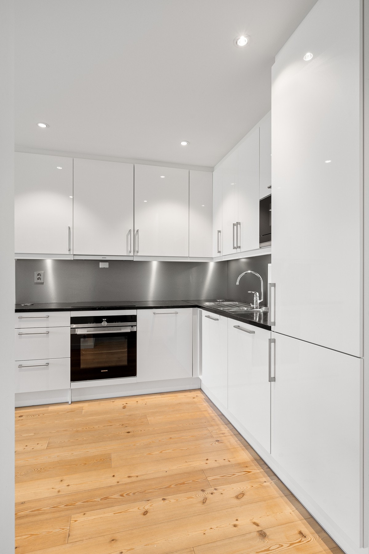 Integrert micro, stekeovn, oppvaskmaskin, kjøleskap og nedfelt platetopp Galleribilde