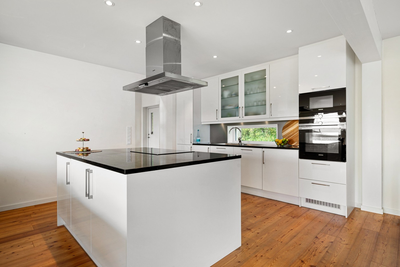 Pen kjøkkeninnredning med fronter i høyglans, takhøye overskap og kjøkkenøy Galleribilde