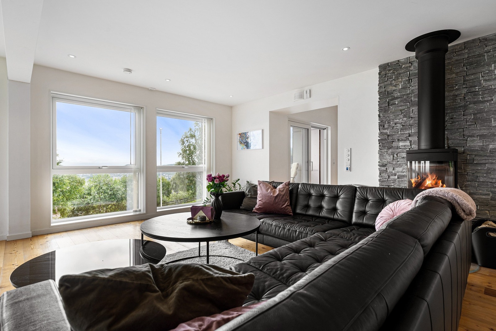 Store vindusflater i stuen sørger for rikelig med naturlig lys og gir en luftig atmosfære Galleribilde