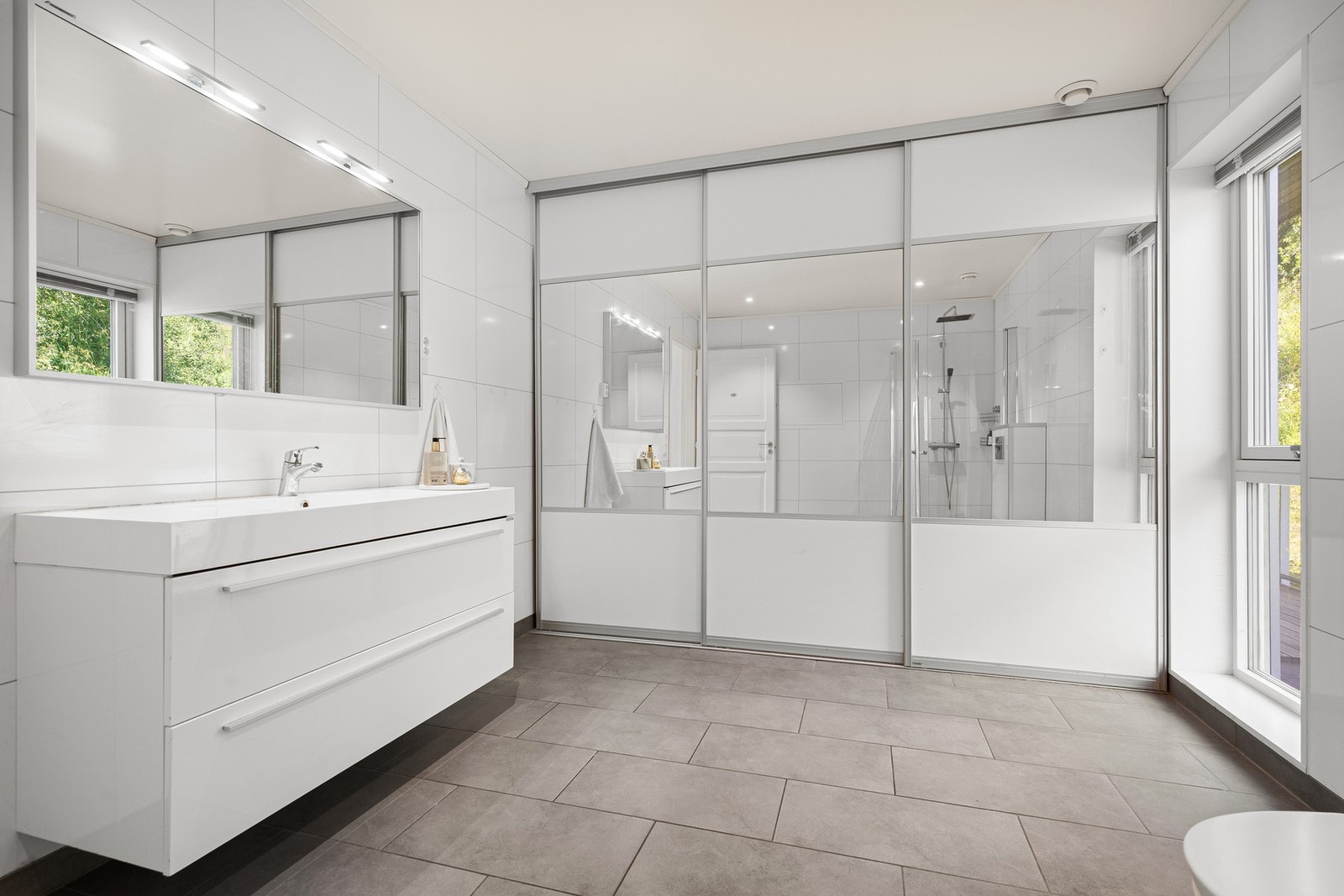 Smart løsning med skyvedører hvor det er opplegg for vaskemaskin skjult bak Galleribilde