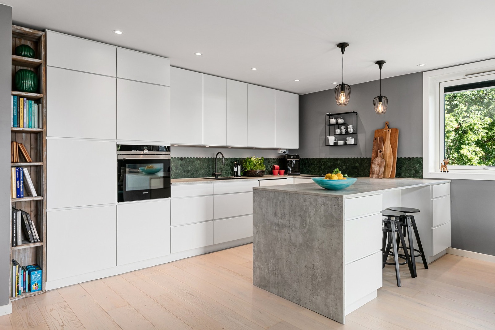 Det åpne kjøkkenet vender mot spisestuen, som igjen åpner seg videre mot stuen - noe som gir gode flater for både måltider og sosialt samvær. Galleribilde