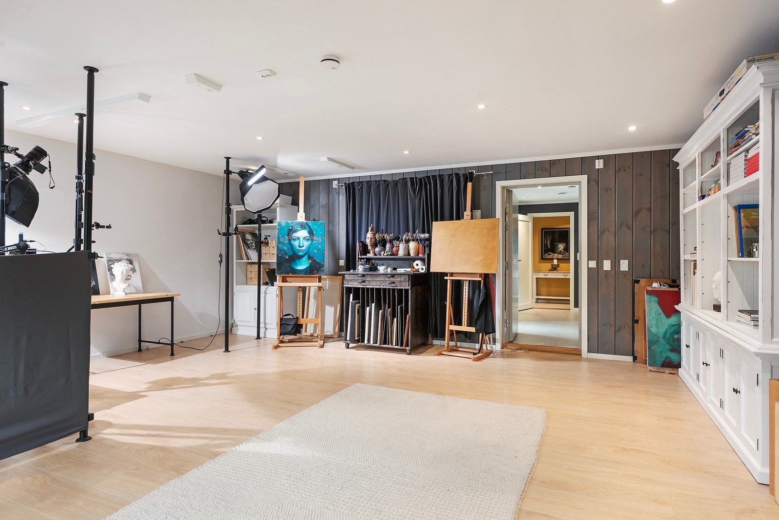 Stort rom som er blitt brukt til fotografering og arbeidsrom. Dette er den tidligere garasjen, garasjeport bak den hviteveggen. Galleribilde