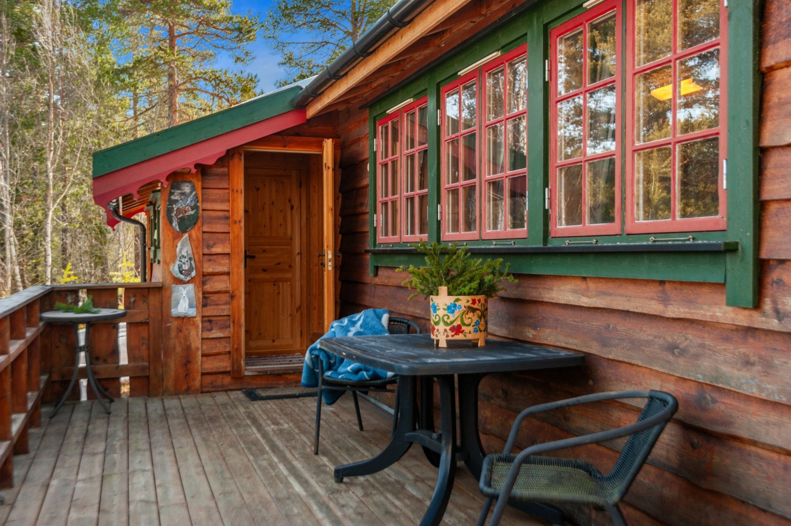 Romslig terrasse som går rundt 2 sider av hytta gir tilgang til sol store deler av døgnet. Galleribilde