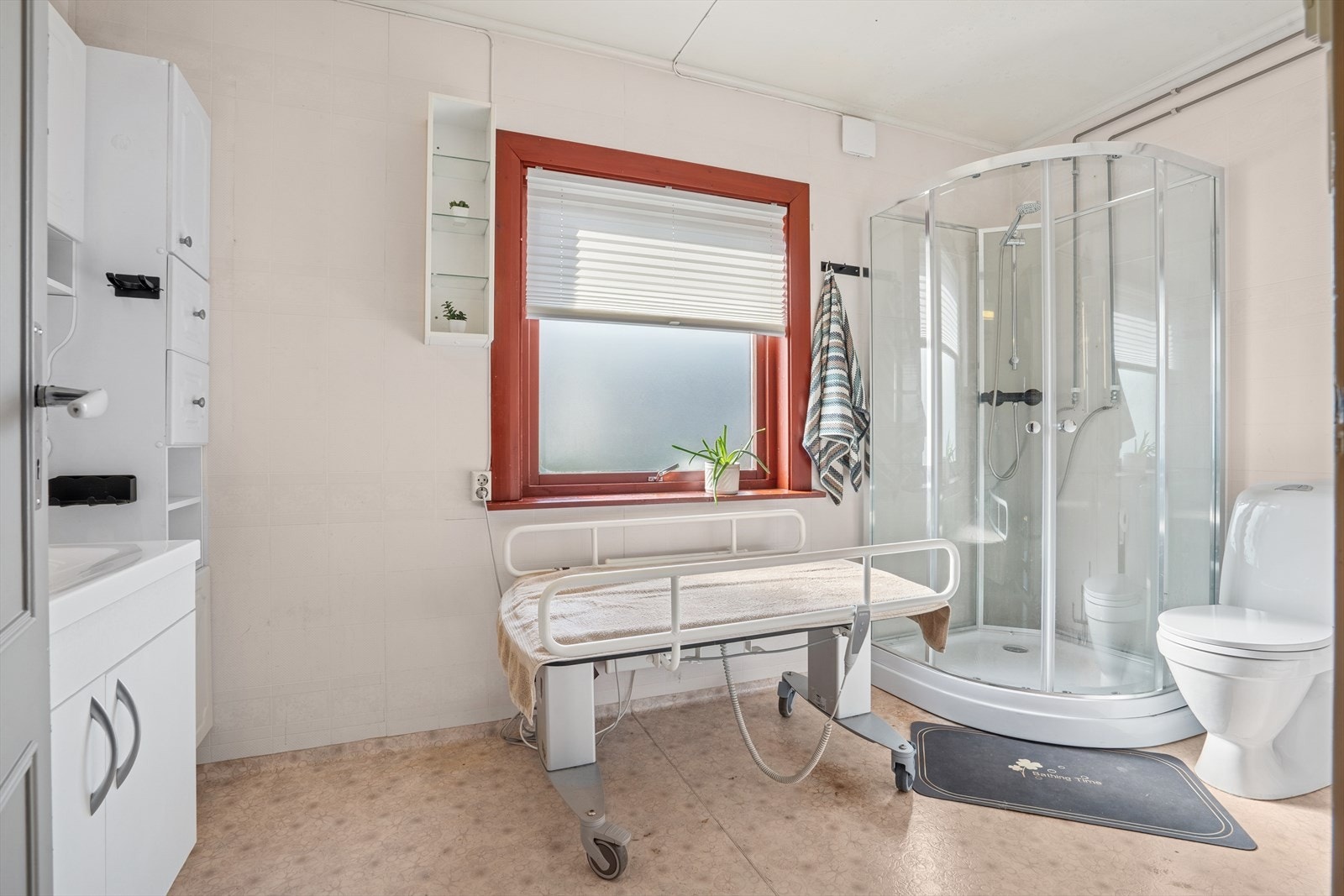 Badet er utstyrt med dusjkabinett, gulvmontert toalett og innredning med servant og ett-greps blandebatteri. Elektrisk gulvvarme som oppvarmingskilde. Det er mekanisk avtrekk via yttervegg. Galleribilde