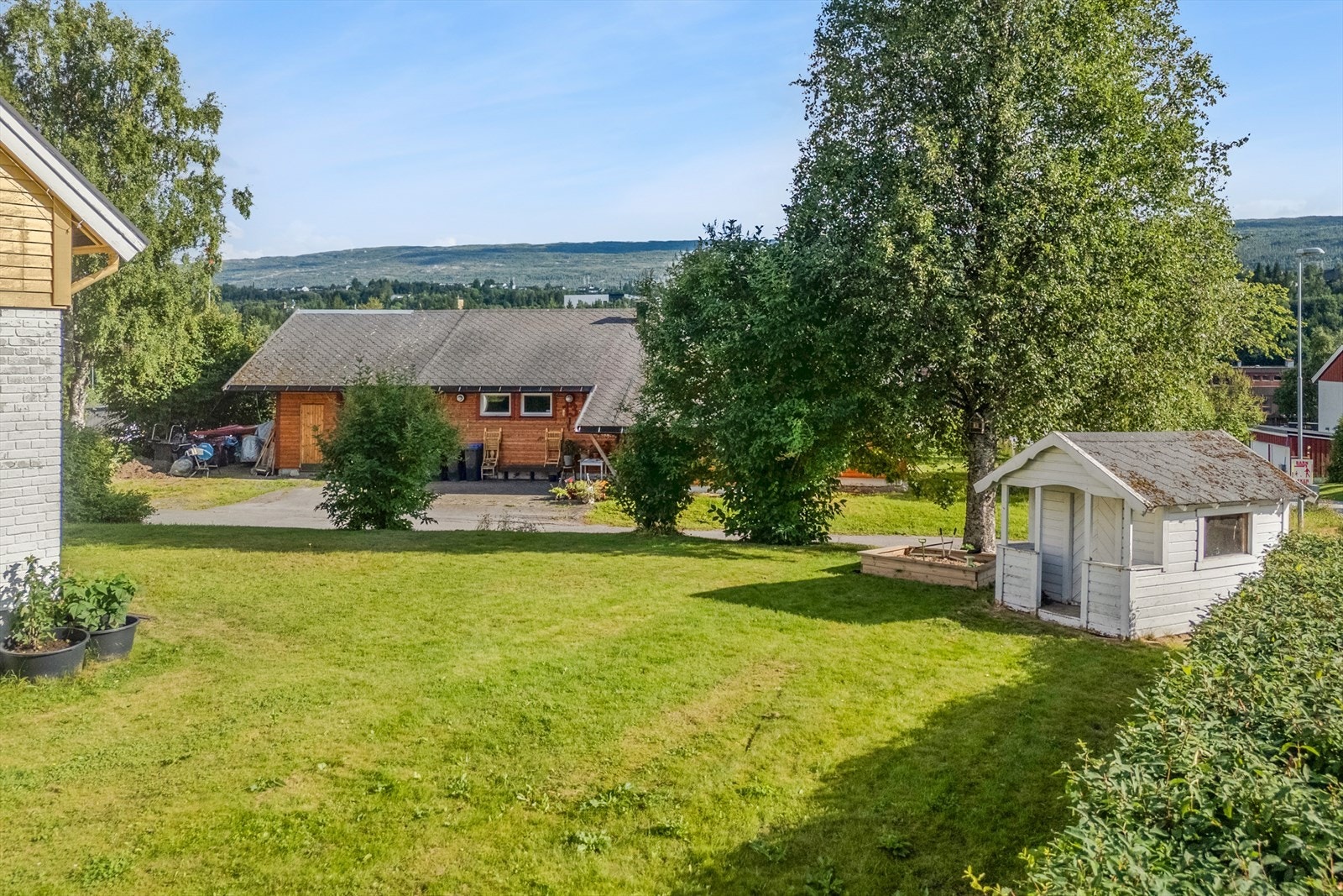 Hagen er pent opparbeidet med bruksplen, busker, hekk og trær. Det er også en liten lekestue som er spennede for barna. Galleribilde