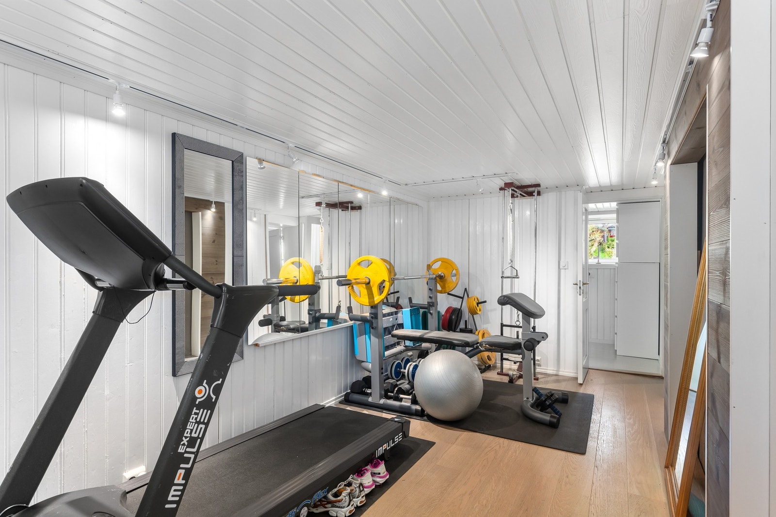 Sokkeletasjen byr videre på en romslig gang som i dag er husets treningsrom. Galleribilde