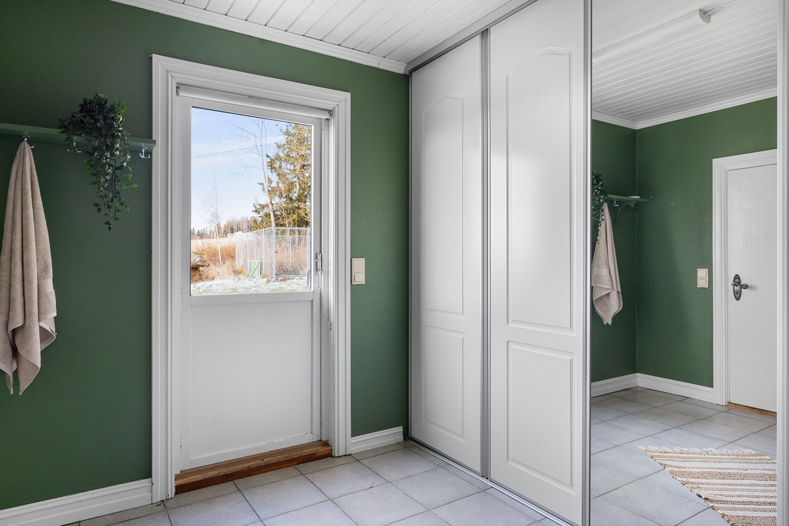 Deler av baderommet fungerer også som en bi-inngang med adkomst fra impregnert platting. Her har du rikelig med oppbevaringsplass i stor plassbygget skyvedørsgarderobe. Galleribilde