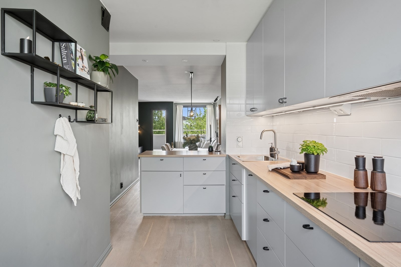 Innredet med glatte, hvite fronter og laminat benkeplate med nedfelt stålkum og ettgreps blandebatteri. Galleribilde
