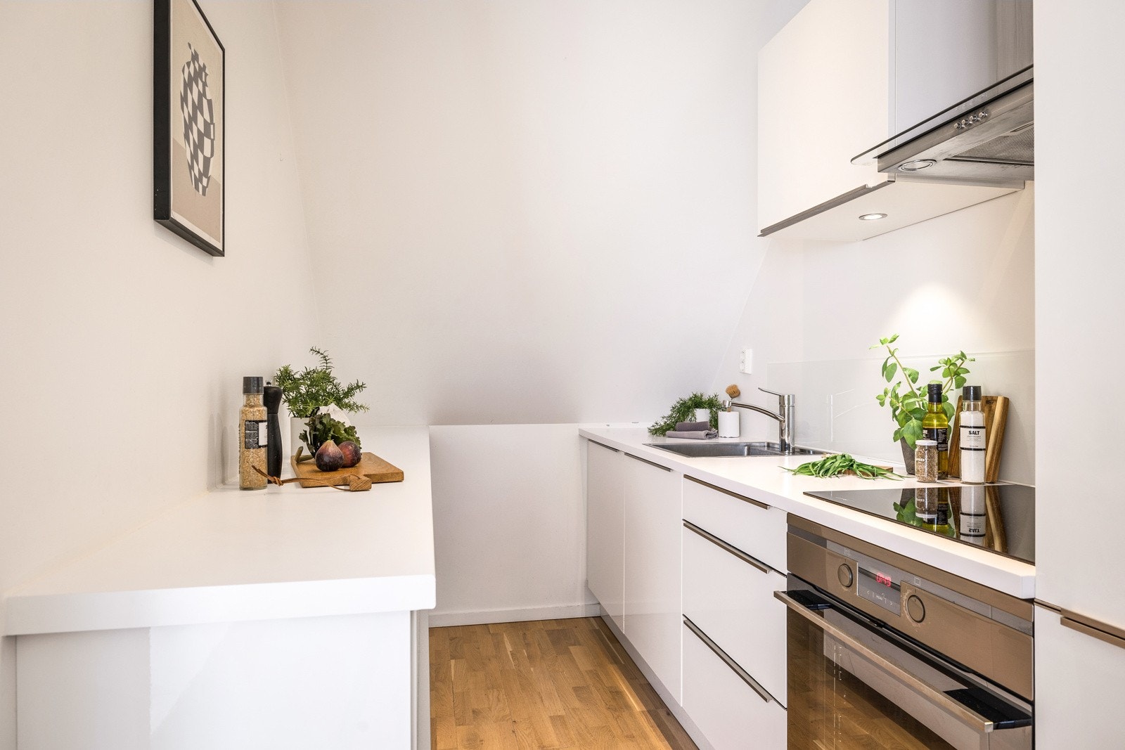 - Kjøkkenet har en smart utforming med benkeplass langs vegg på begge sider som igjen sikrer god plass under matlagingen - Galleribilde