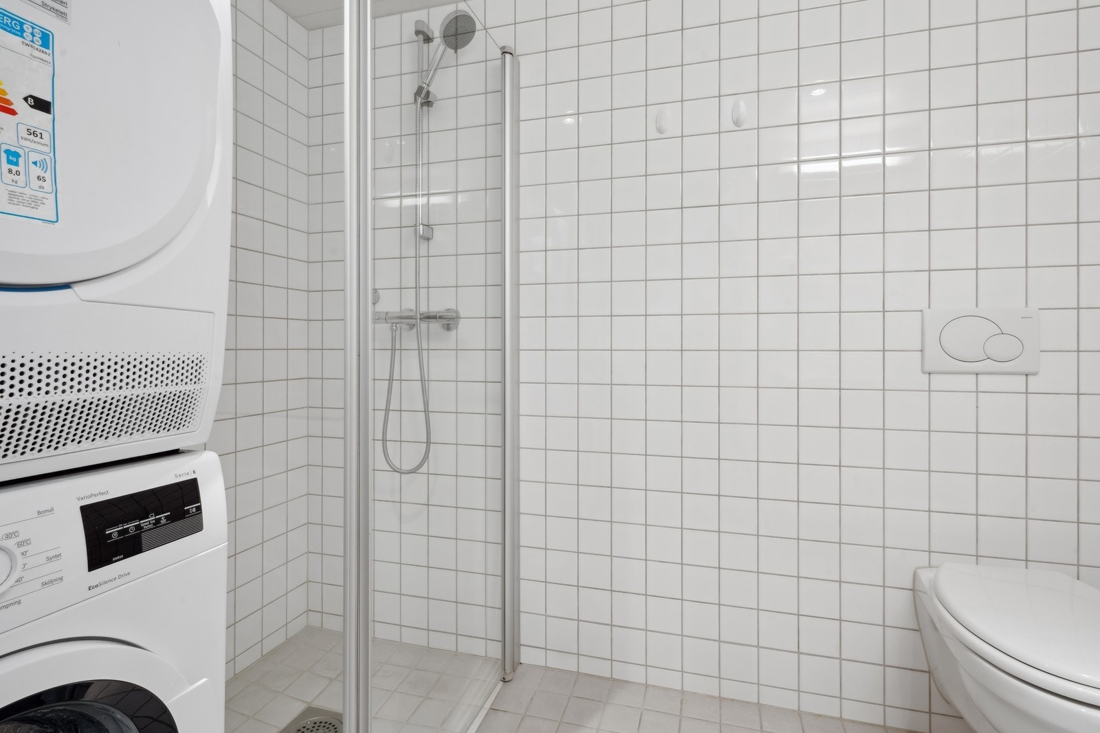 Flislagt baderom med vaskemaskin og tørketrommel. Galleribilde