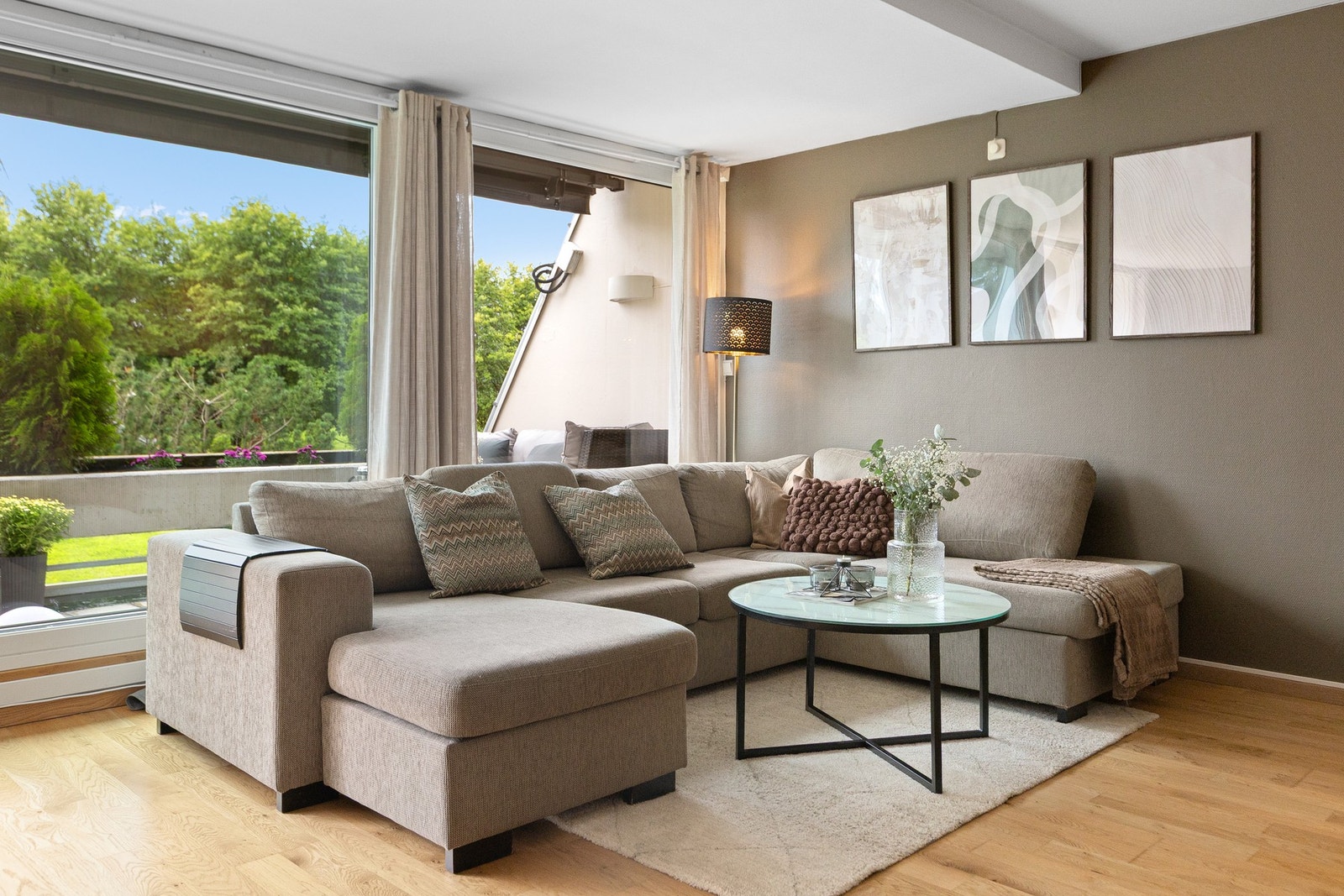 Lys og moderne stue med god plass til en romslig sofaseksjon og tilhørende møblement. Galleribilde