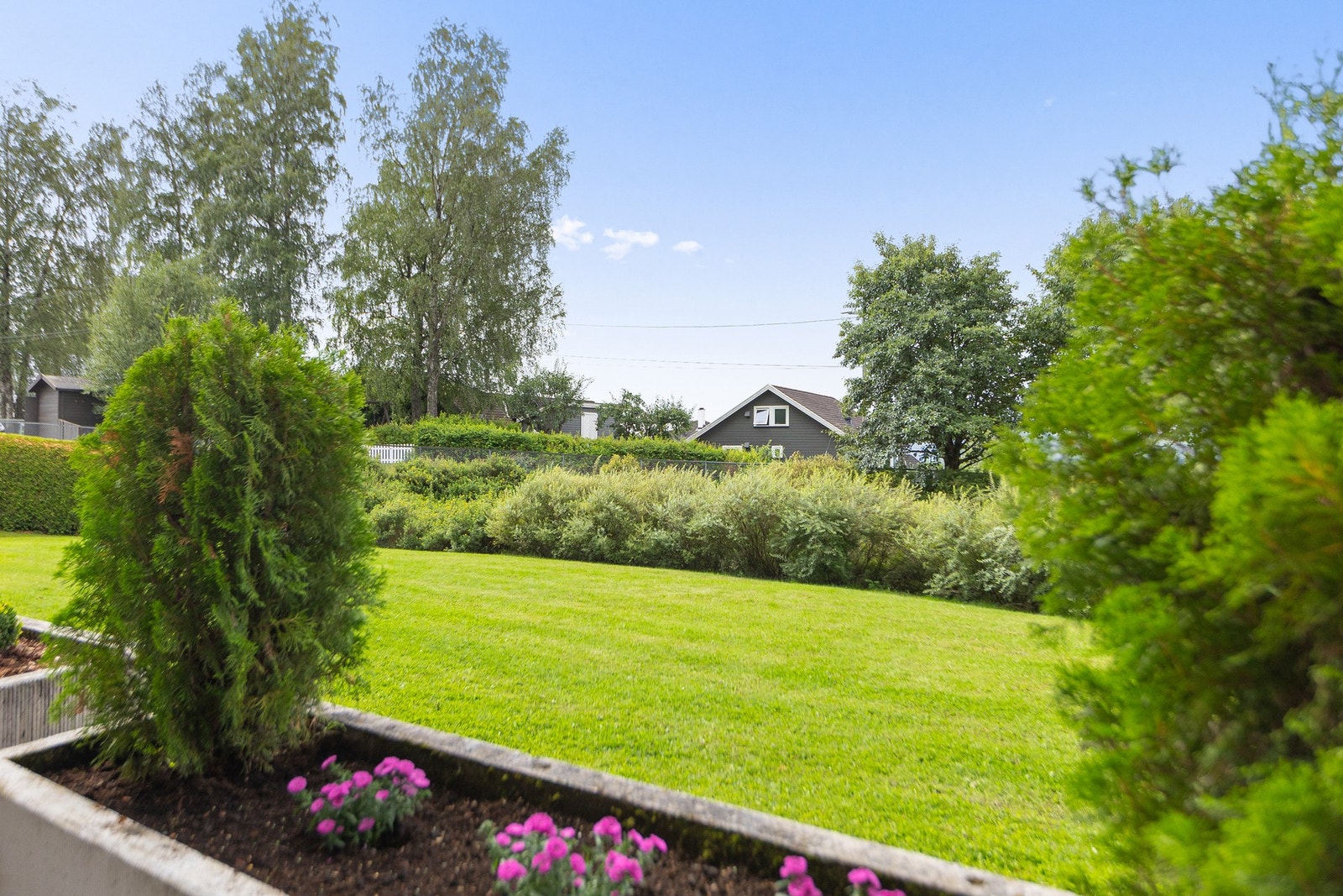 Utsikt mot et pent og opparbeidet plenområde. Galleribilde