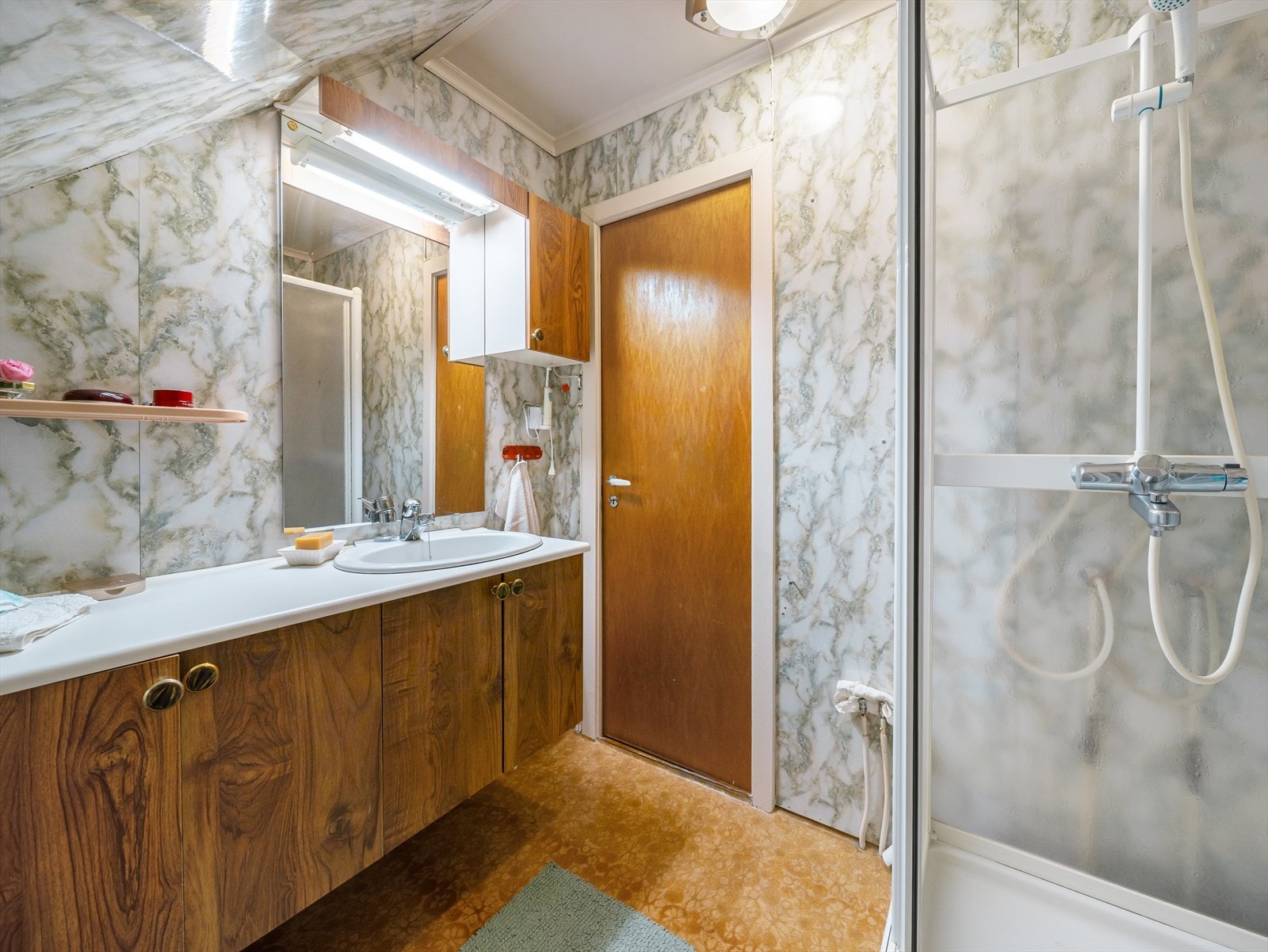 Badet er innredet med servant i baderomsmøbel og dusjkabinett. Galleribilde