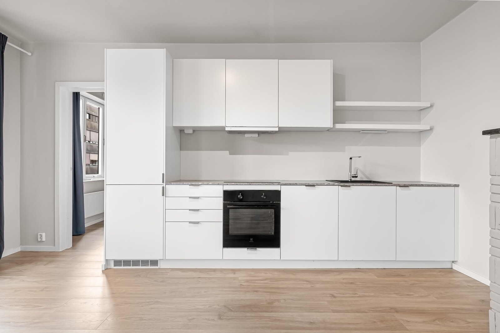 Kjøkkeninnredning med hvite glatte fronter m/ integrerte grep. Galleribilde