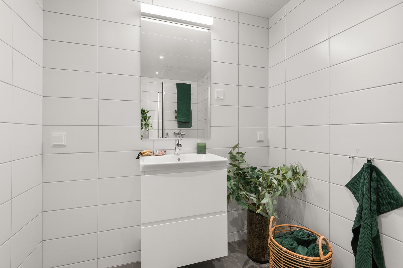 Tidløs baderomsinnredning med heldekkende servant og servantskuffer. Nisje for vaskemaskin i innredningen. Bilde lånt fra stylet og tilsvarende leilighet etasjen over. Galleribilde