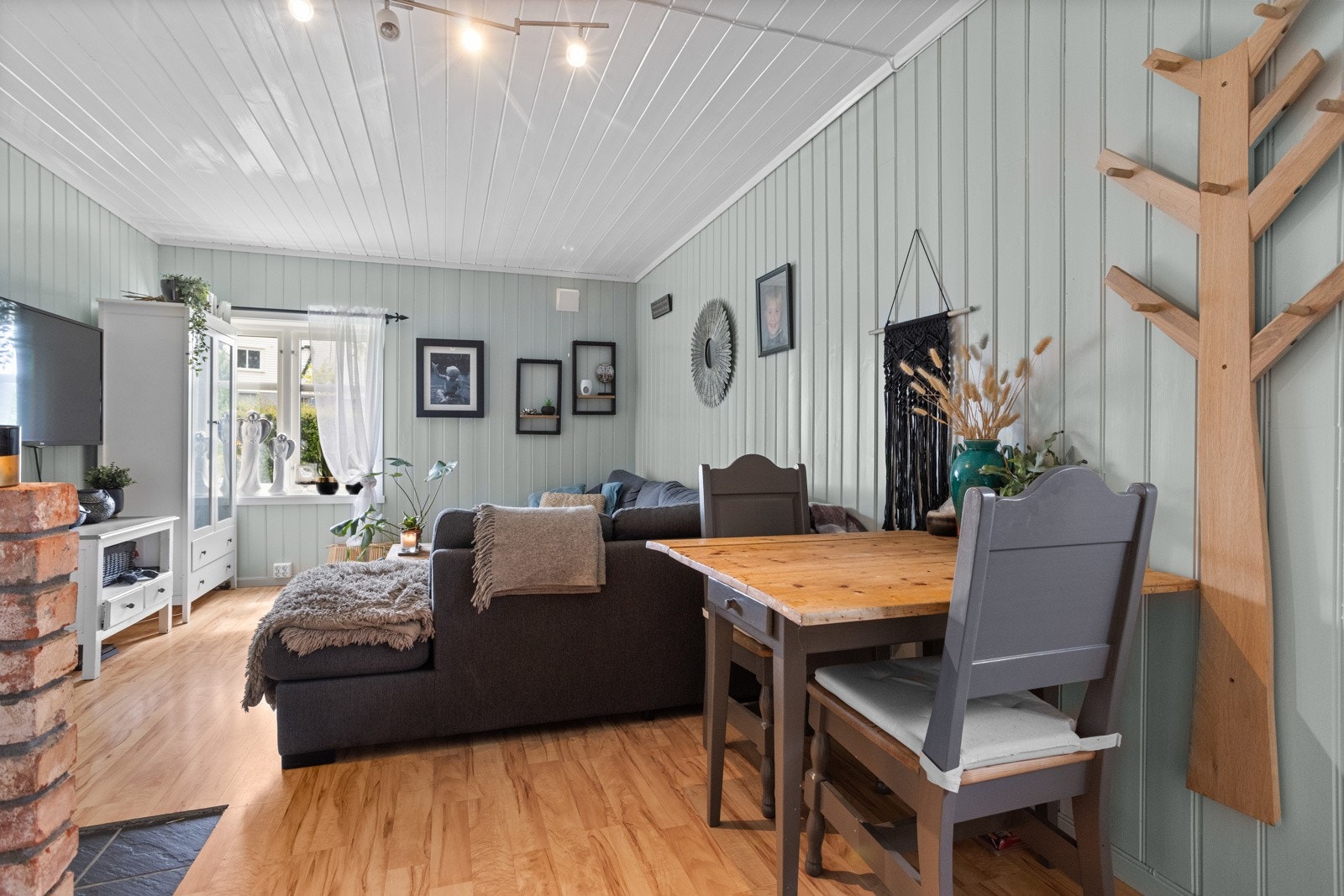 Stuen og kjøkkenet ligger i åpen løsning, med plass til sofagruppe og et lite spisebord Galleribilde