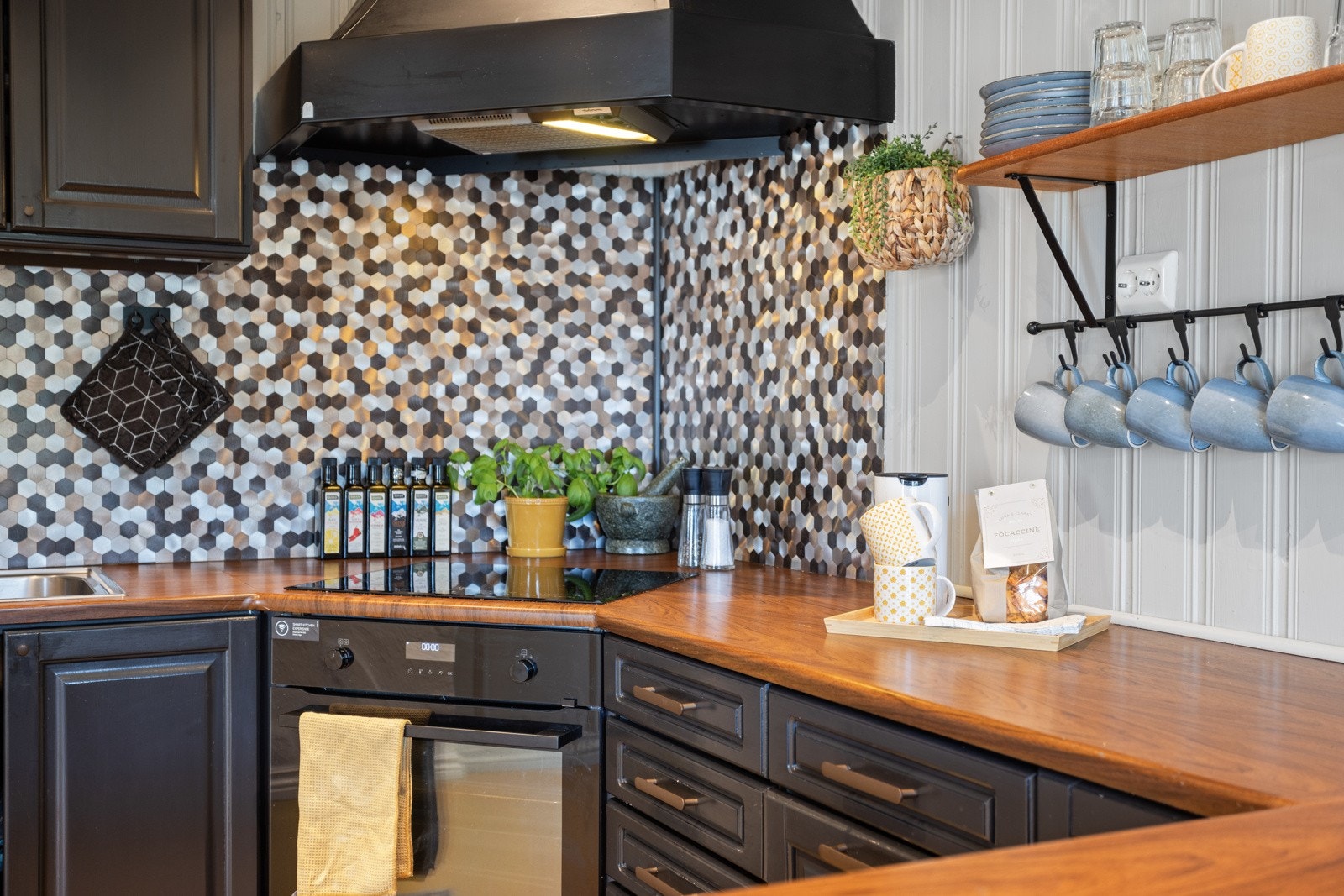 Innredningen har mørke, profilerte fronter i ask og benkeplate av laminat med dobbel oppvaskkum i stål Galleribilde