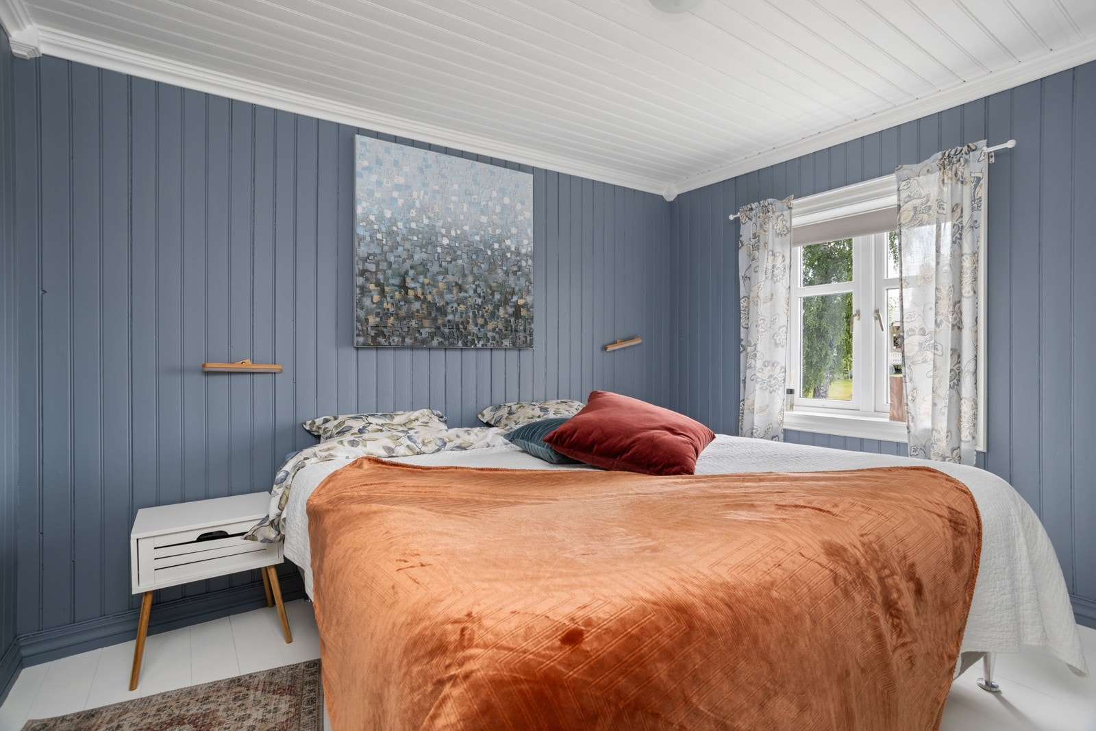 På hovedsoverommet er det plass til dobbeltseng med tilhørende nattbord, og for en lun atmosfære ble veggene malt i en mørk og moderne blåfarge i 2 Galleribilde