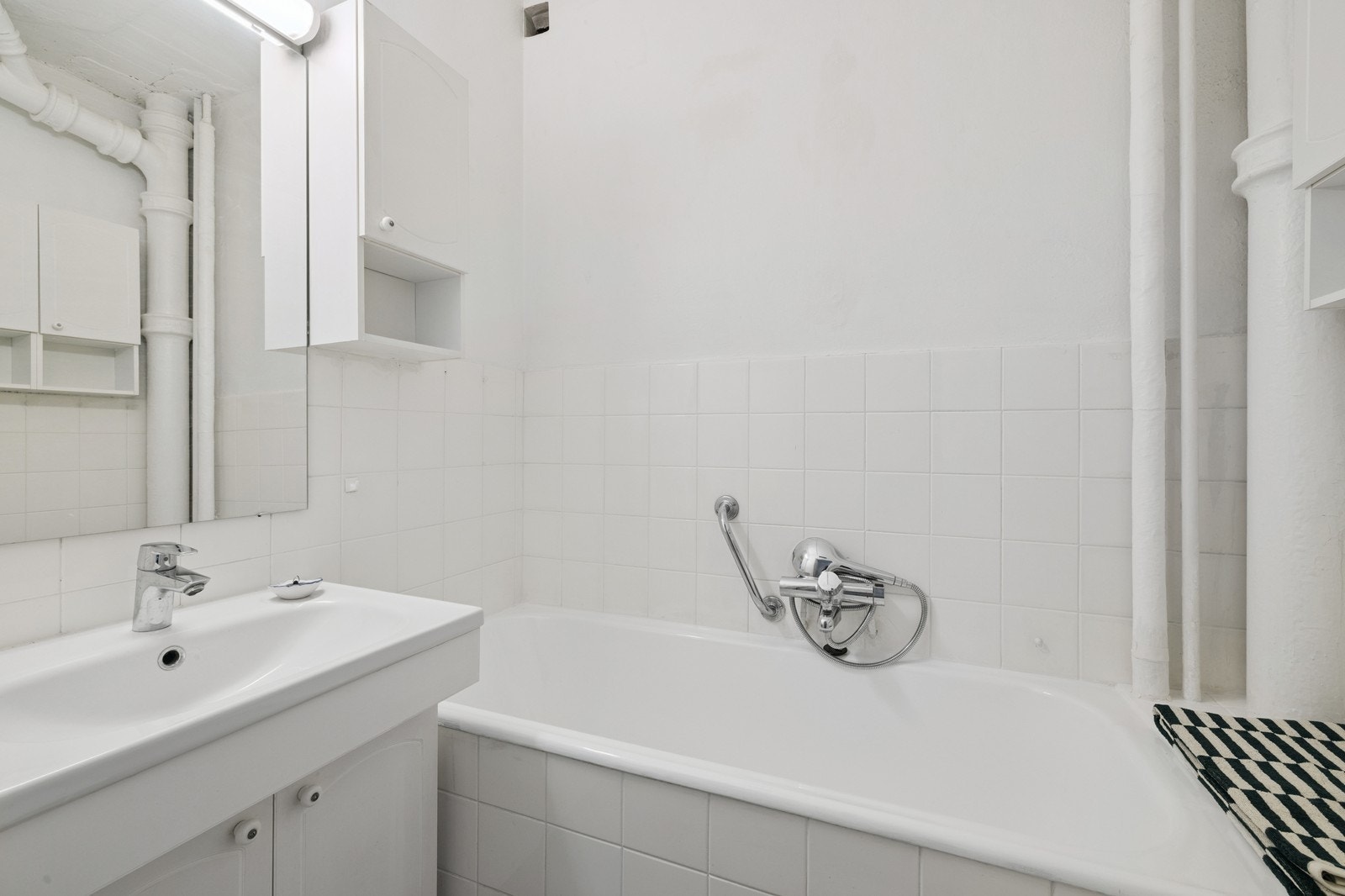 Flislagt baderom med badekar, toalett og servant. Galleribilde