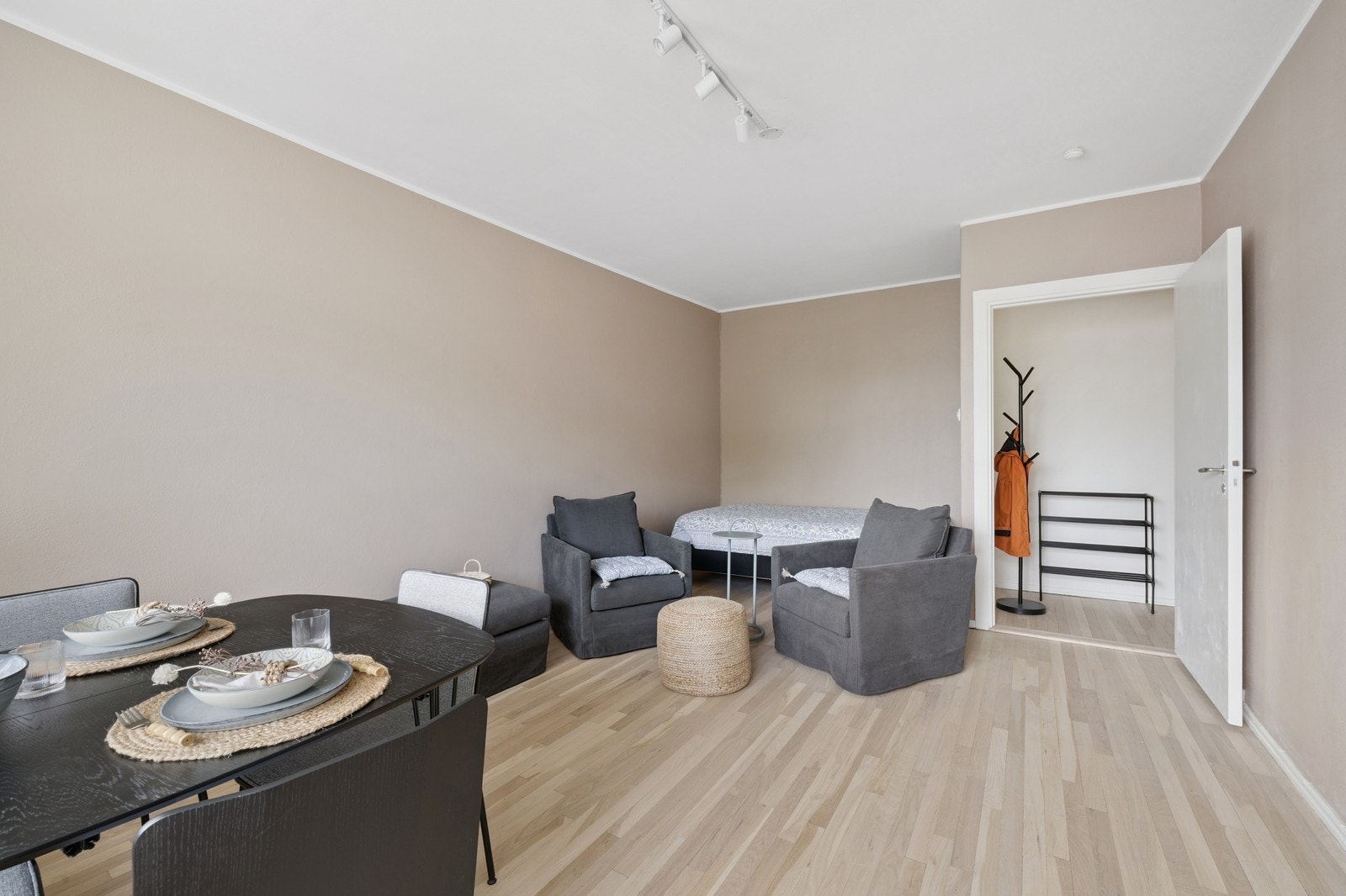 Stuen er møblert med to sittegrupper og seng. Galleribilde