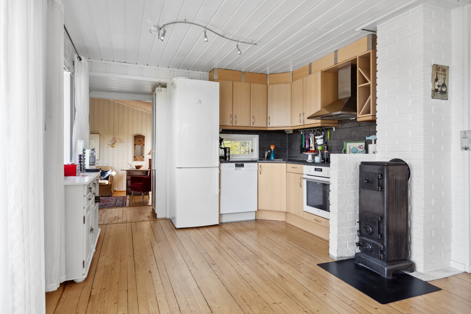 Kjøkkenet er praktisk utstyrt med slette fronter, laminert benkeplate, integrert komfyr og induksjonstopp, frittstående kjøleskap og oppvaskmaskin. Det er kjøkkenventilator med avtrekk ut Galleribilde