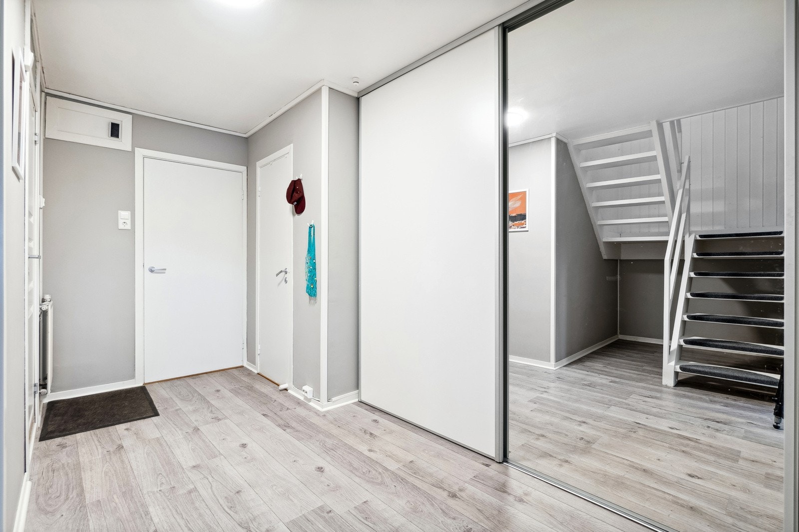 Her finner du en bod like til venstre og videre inn i gangen er det montert skyvedørsgarderobe for praktisk oppbevaring av klær, utstyr, o.l Galleribilde