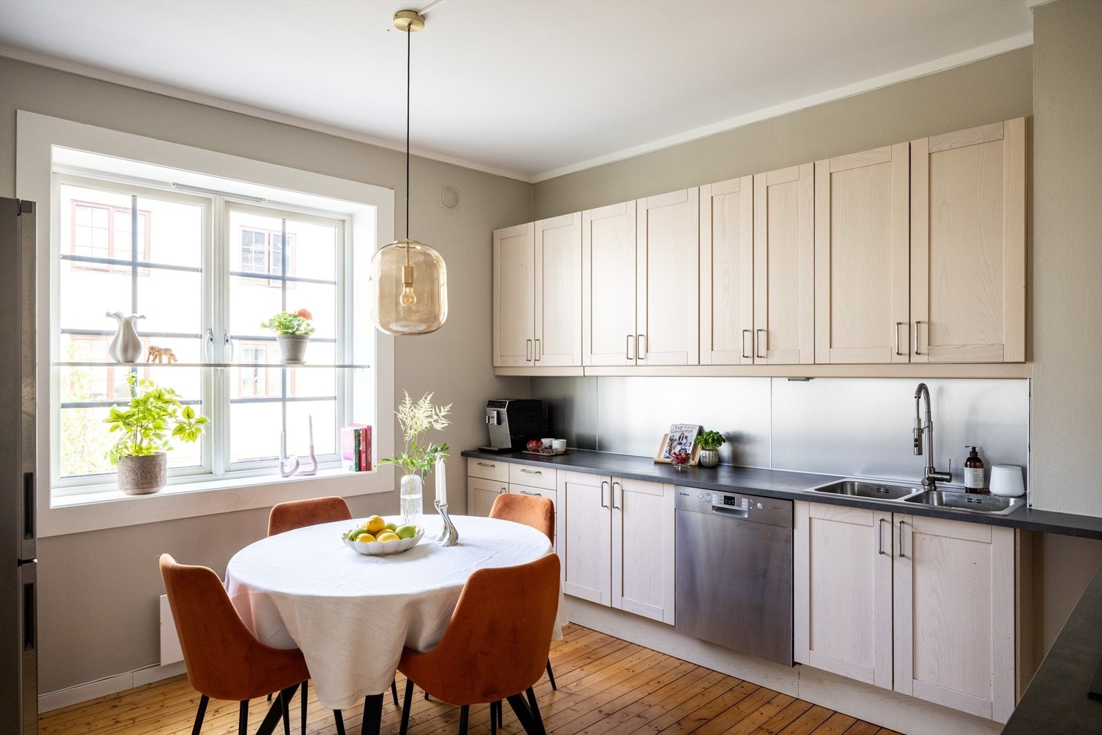 Lyst og flott kjøkken bestående av hvite, profilerte fronter og benkeplate av laminat med nedfelt vask. Galleribilde