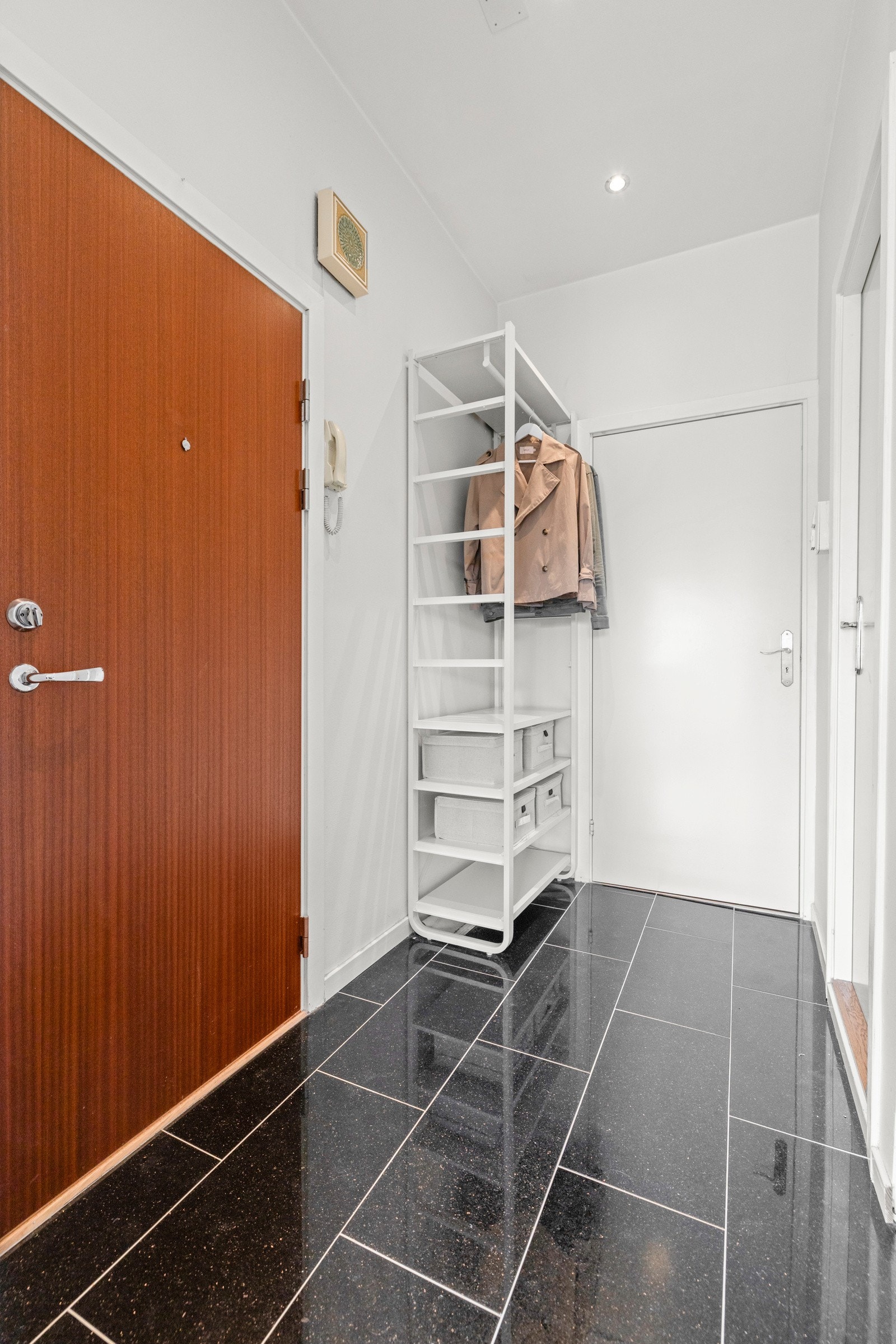 Entréen har flislagt gulv og malte vegger som gir en enkel og ren overflate Galleribilde