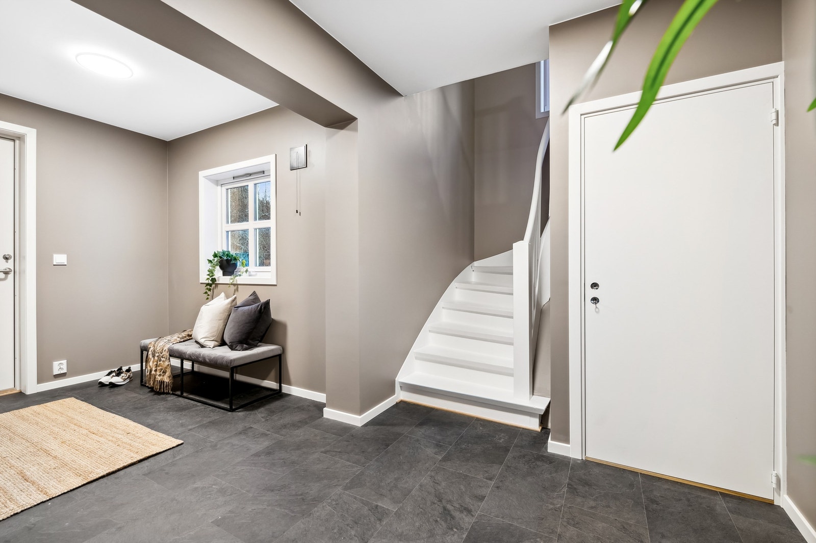 Romslig entré med varmefolie i gulv fra 2022 - praktisk for hele familien. Der krakk og vindu fremkommer av dette bildet, er det etablert en dør til påbygget inngangsparti til kjellerleiligheten. Galleribilde