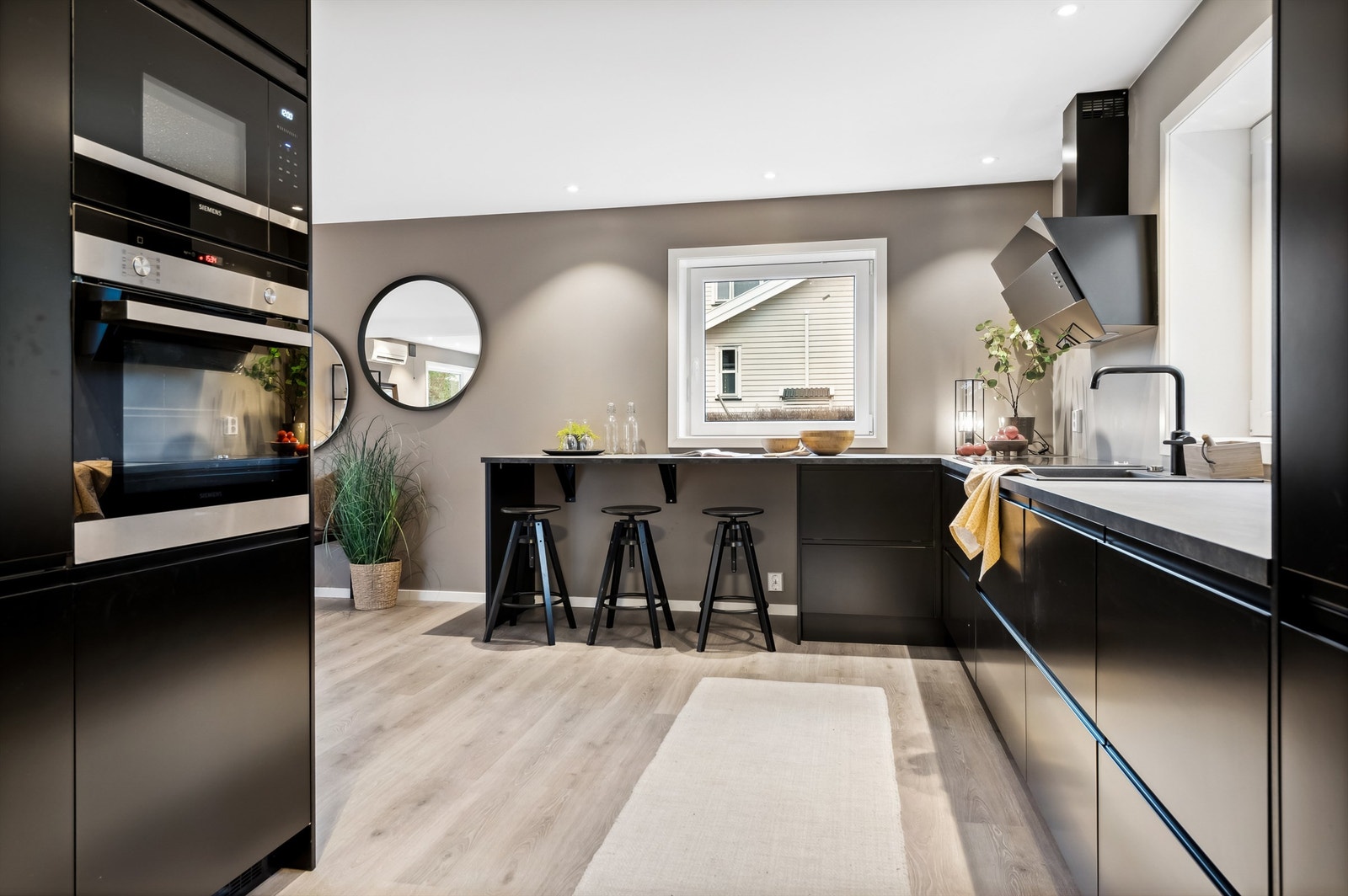 Innredningen har glatte fronter og praktisk barløsning ved vinduet hvor frokosten og kaffekoppen kan nytes Galleribilde