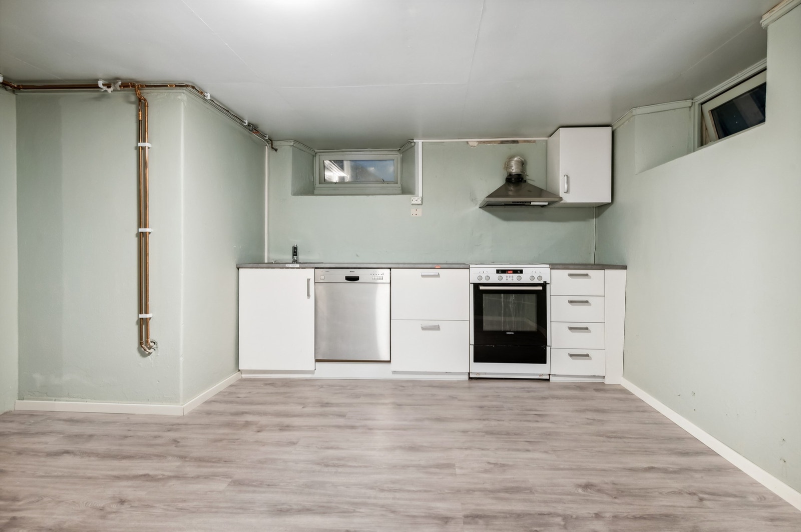 Kjellerkjøkken med laminerte fronter og god plass til frittstående hvitevarer. Galleribilde