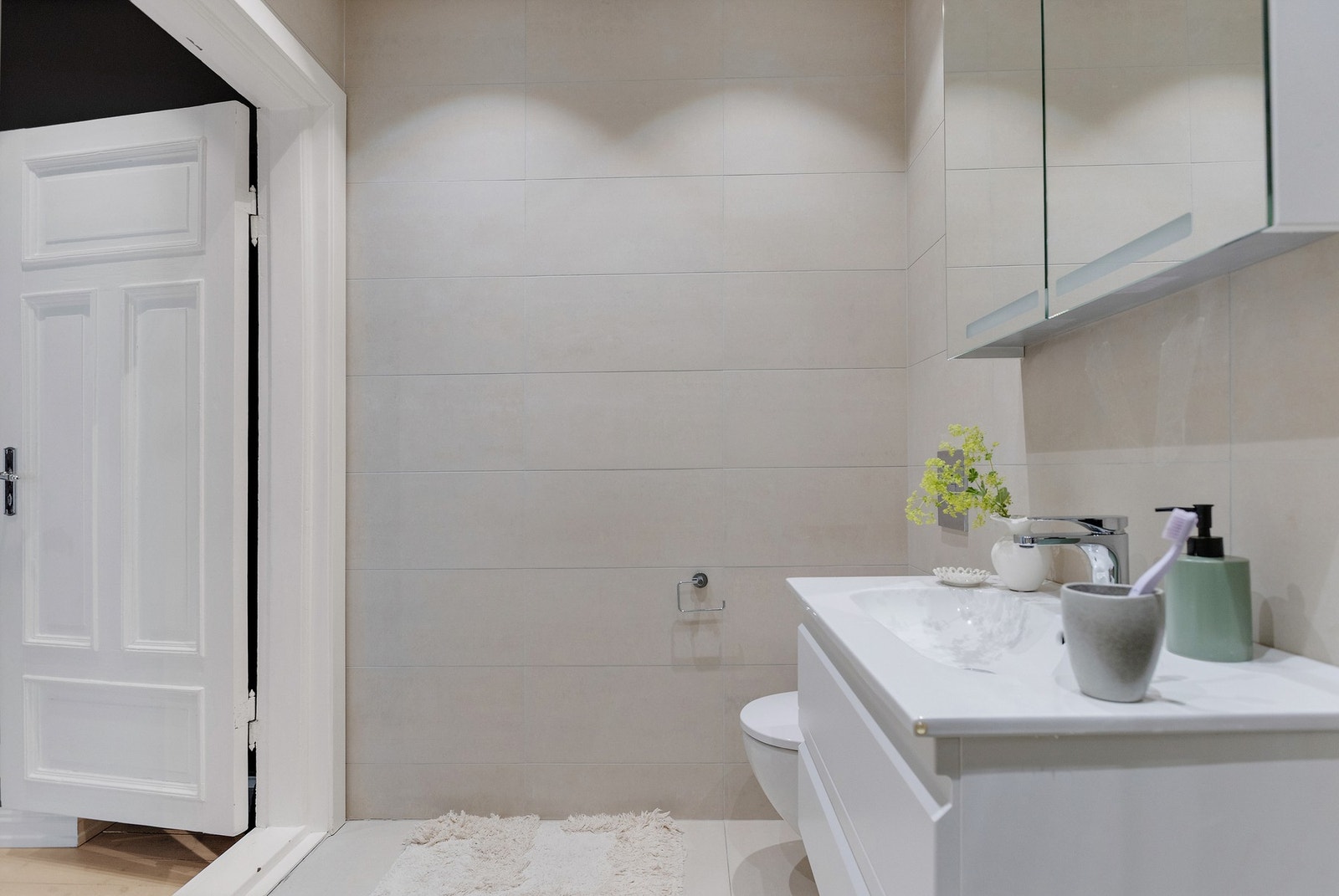 Videre inneholder badet dusjhjørne med innfellbare glassdører og hånddusj/regnfallsdusj, samt vegghengt toalett. Galleribilde