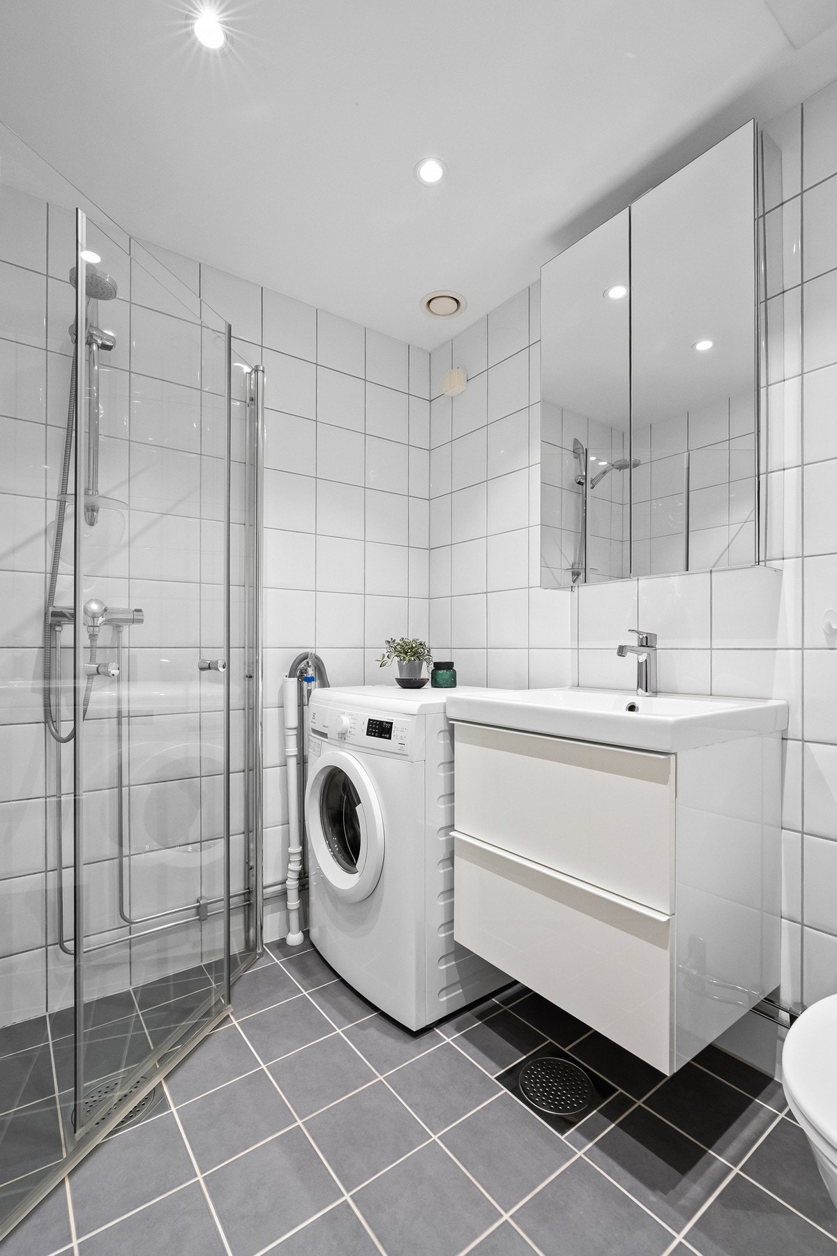 Badet er innredet med servant, toalett, dusjhjørne og opplegg for vaskemaskin. Det er også tilgang til fellesvaskeri. Galleribilde