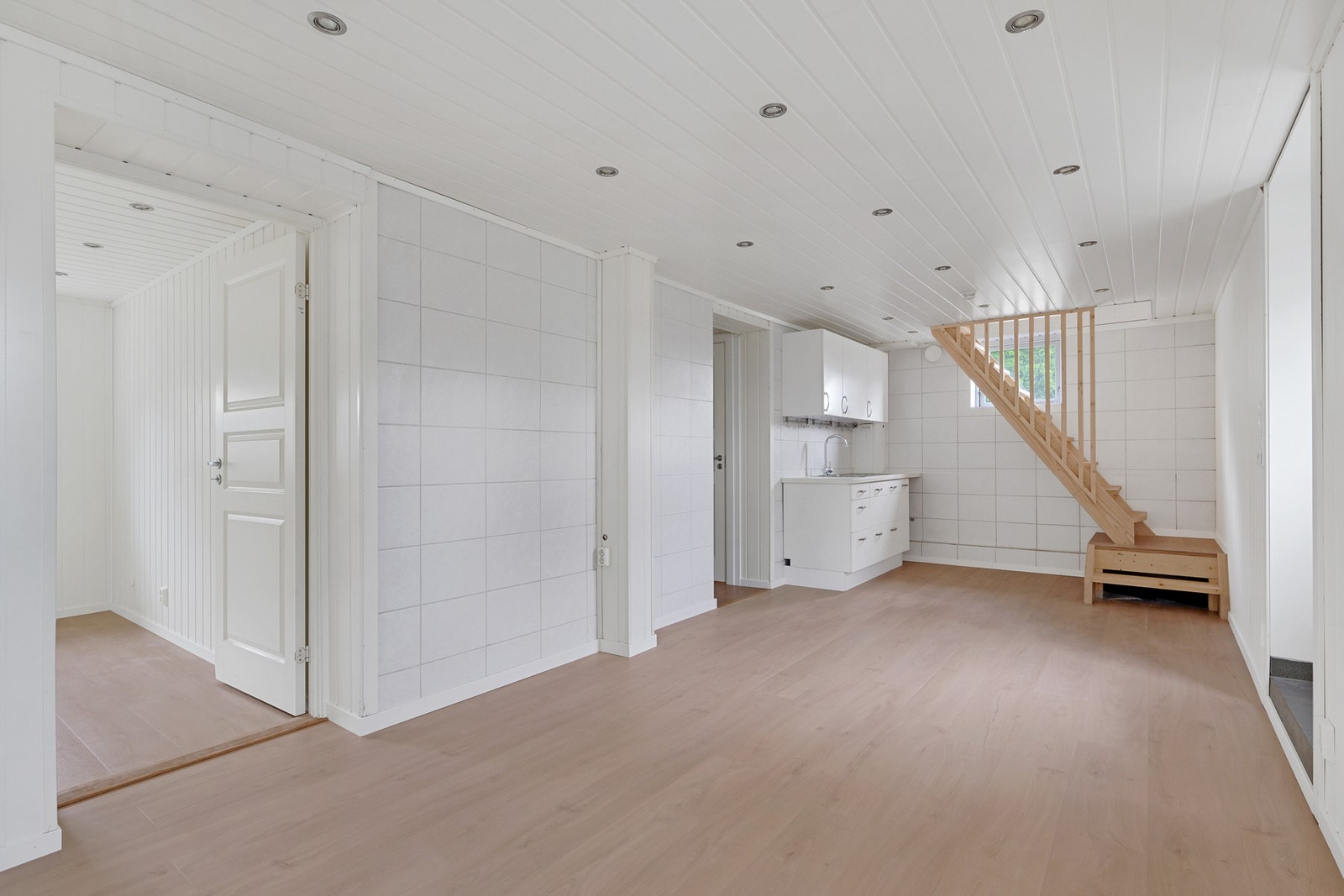 Kjellestue med kjøkkenkrok og innvendig trapp til hovedetasjen Galleribilde