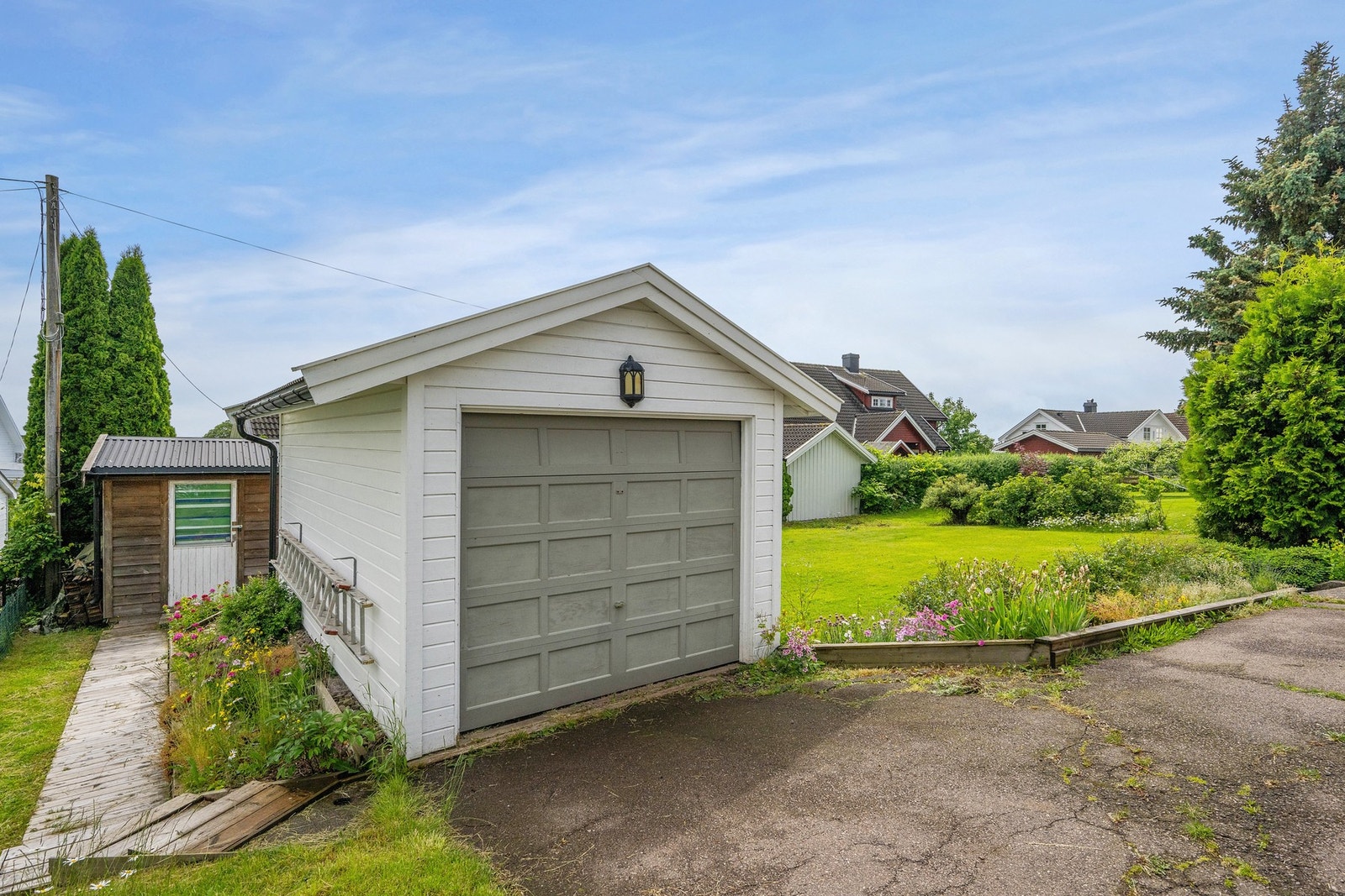 Det er både biloppstillingsplass foran huset og garasje med aut. portåpner Galleribilde