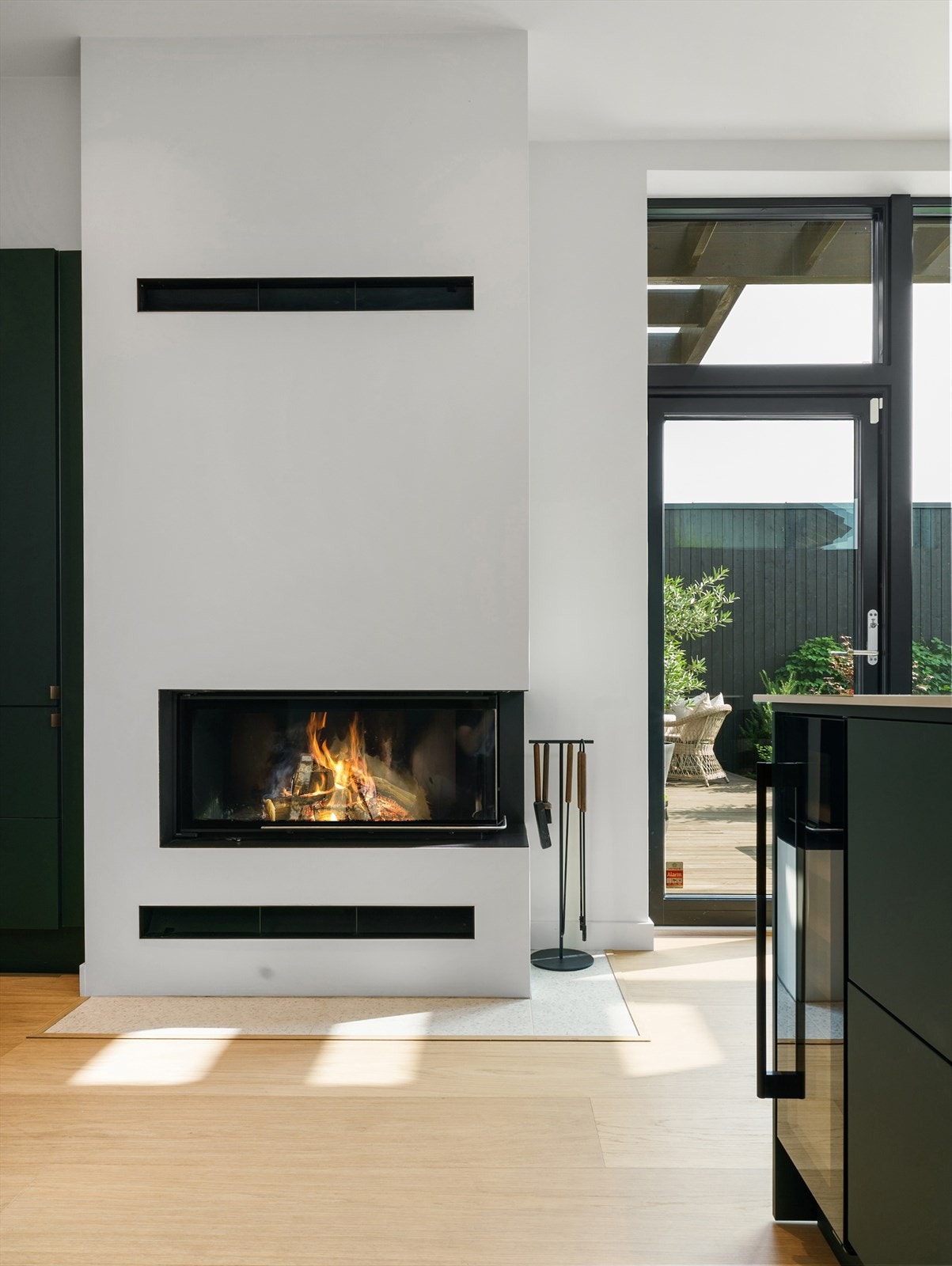 På stuen er det en arkitekttegnet peis med eksklusiv innsats fra tyske Brunner med sømløst glass fra 2 sider med hev/senk Galleribilde