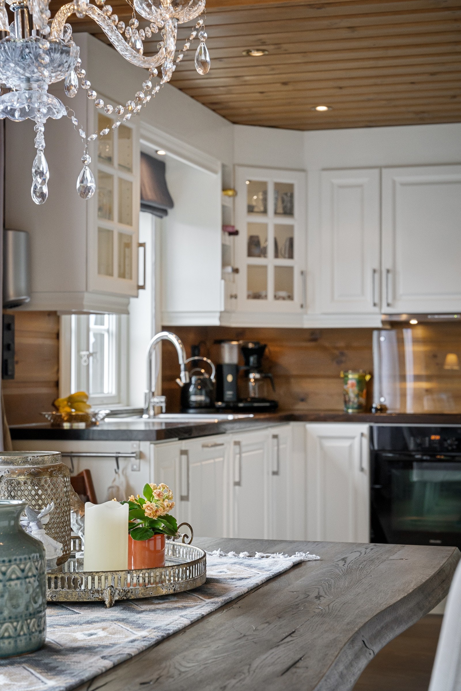 Kjøkkenet er lyst og moderne med profilerte fronter og mørke benkeplater som står i stil til resten av hytta. Galleribilde