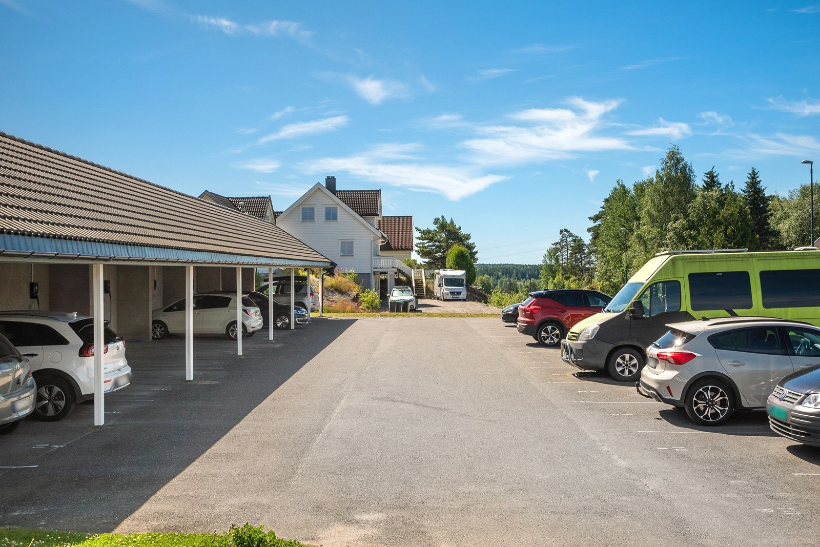 Parkering gjøres enkel i carport, det er montert ladeboks. Eier oppretter eget ladeabonnement via Elaway. Det er flere gjesteplasser på feltet. Galleribilde