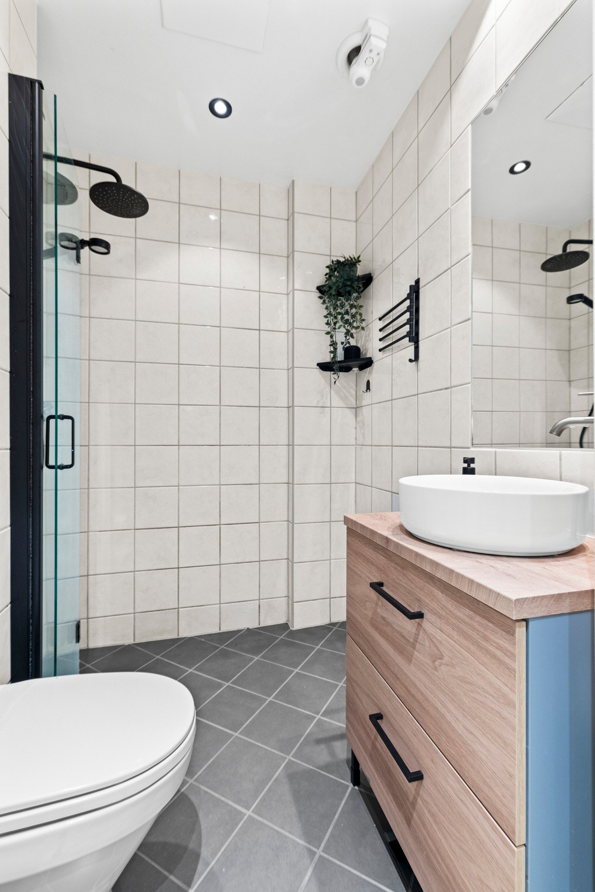 Her finner du innredning med slette fronter og benkeplate i laminat, servant med ett-greps armatur, dusjhjørne med innfellbare glassdører, samt dusjarmatur tilkoblet både regndusj og hånddusj. Galleribilde