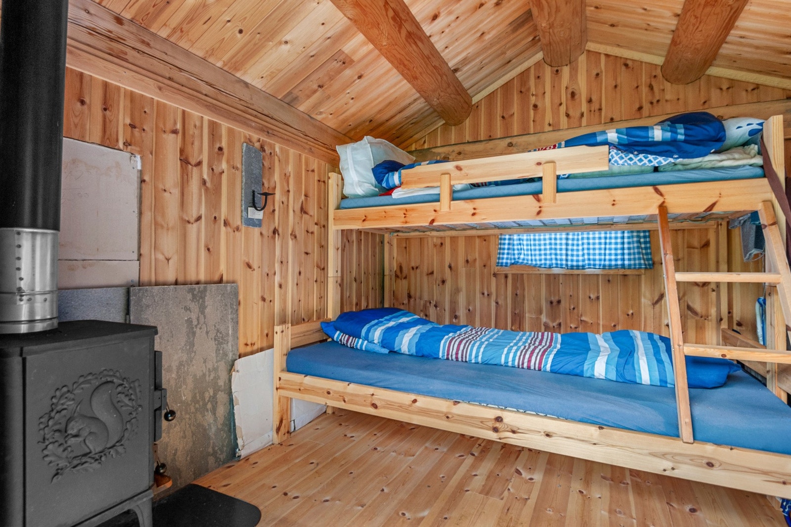 I uthuset har man familiekøye og vedovn. Galleribilde